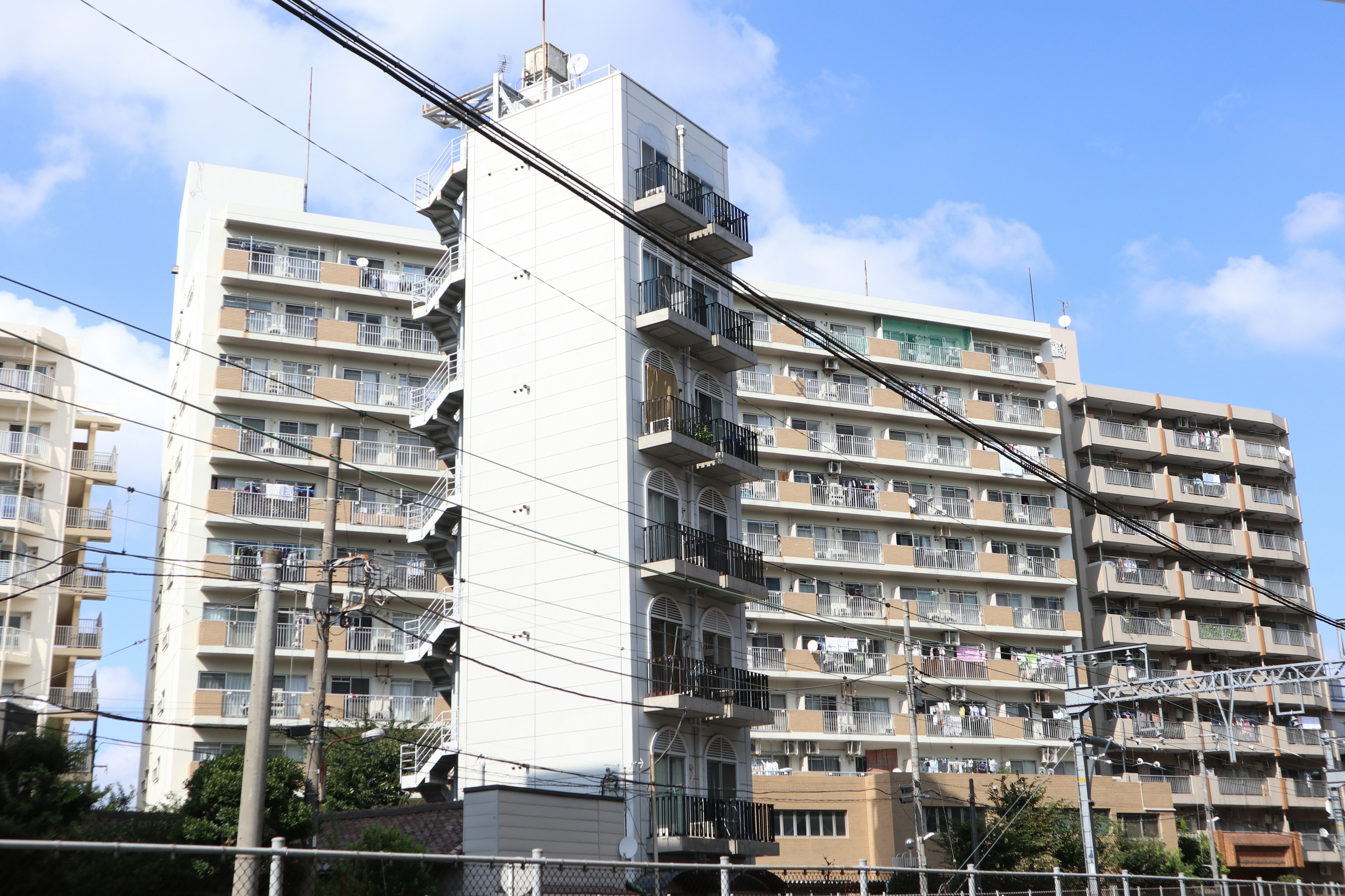 Bangunan apartemen dengan eksterior putih dan langit biru