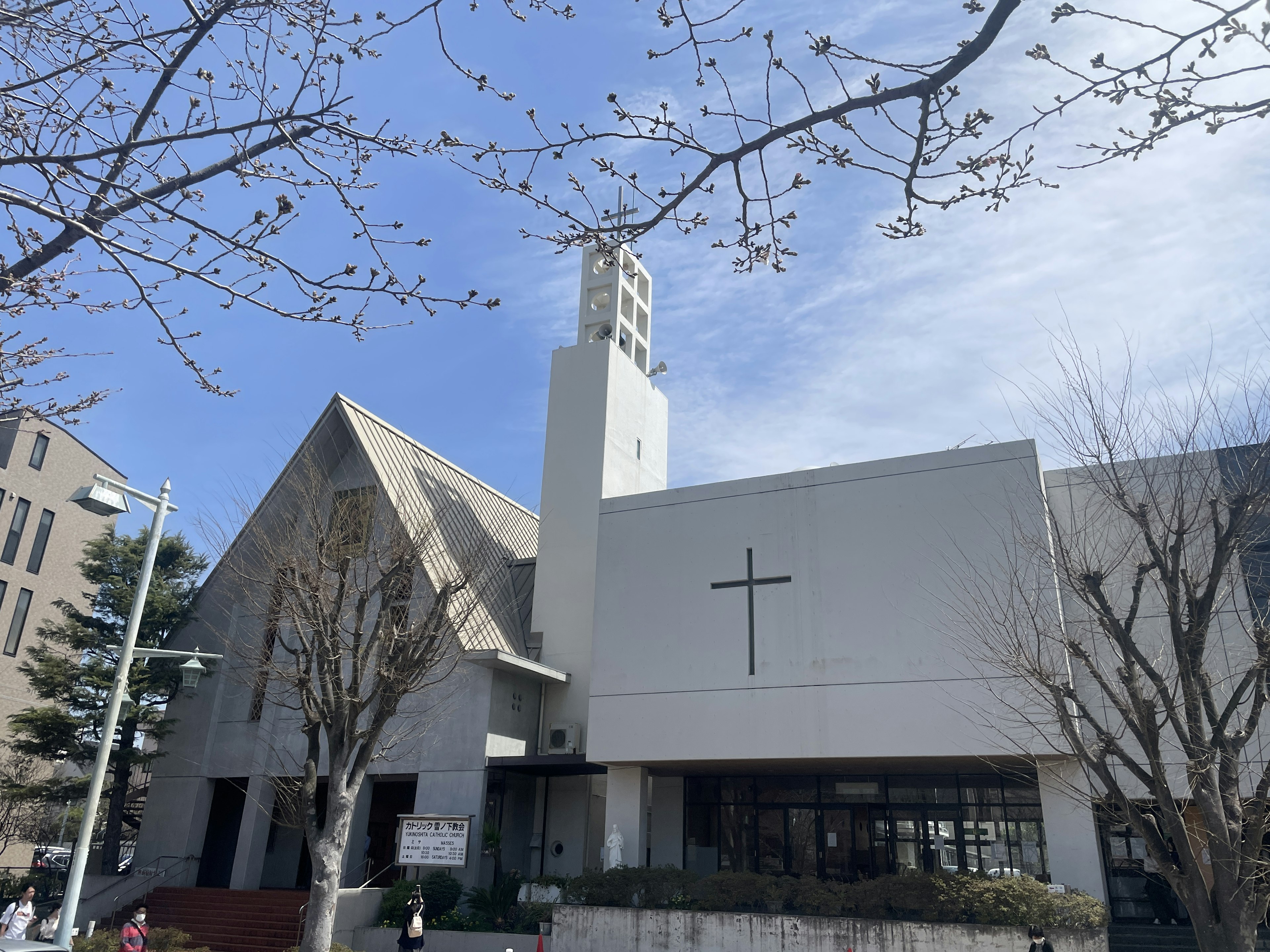 Exterior of a church with a white building and a cross