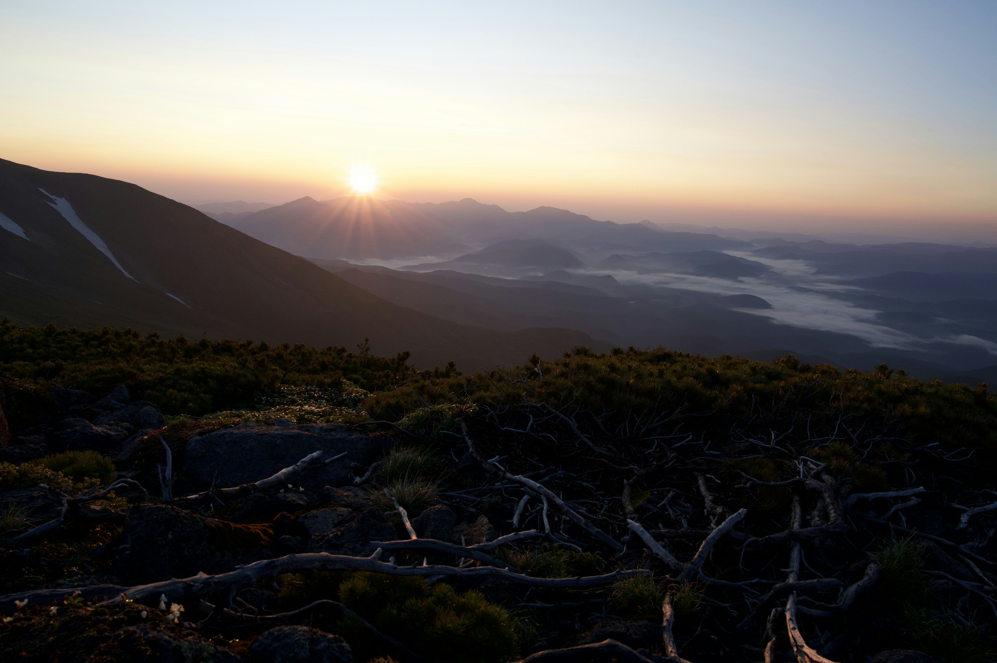 Sonnenaufgang über Bergen mit Nebel in den Tälern