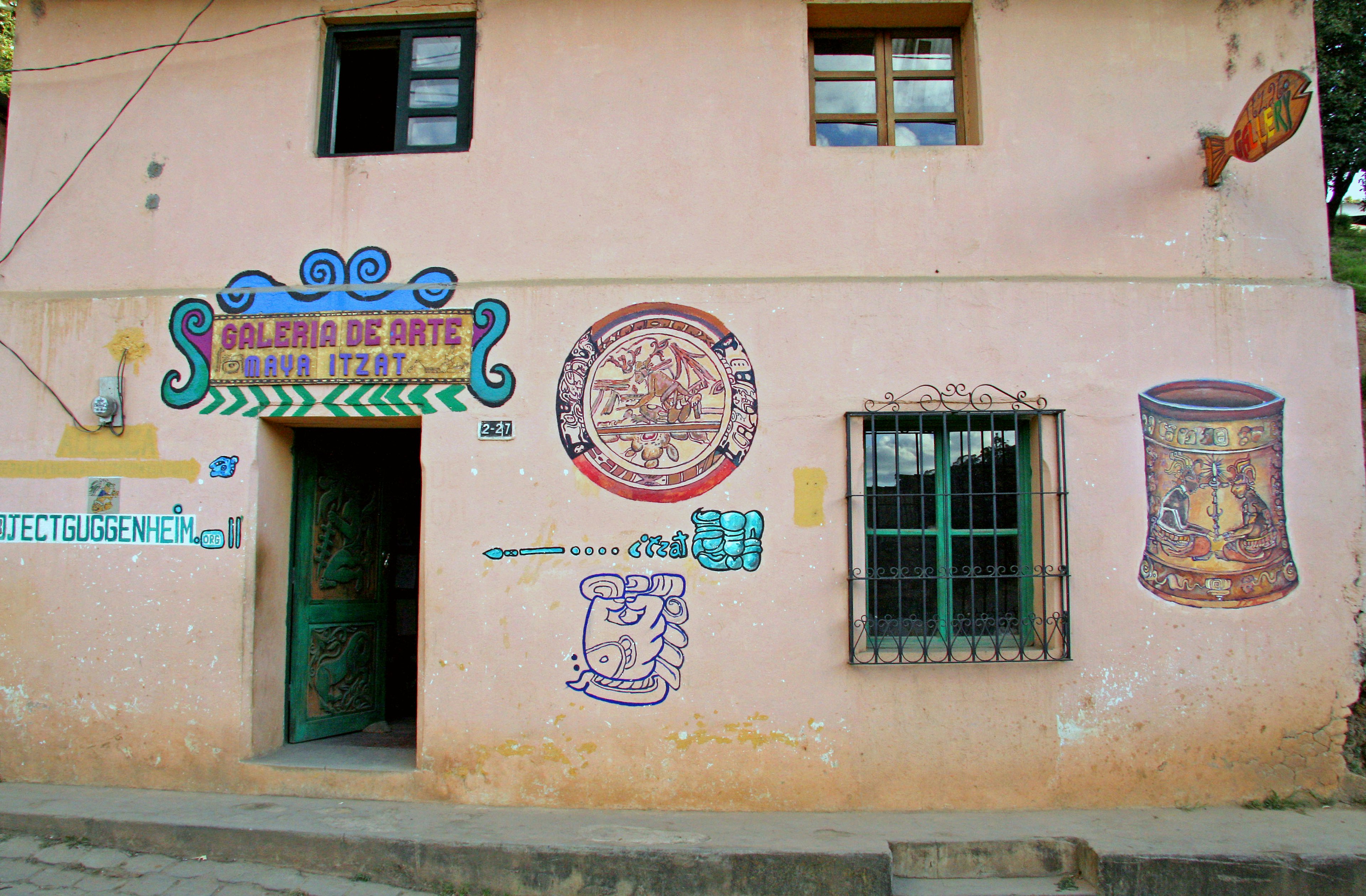 Colorful wall art on a pink house with windows