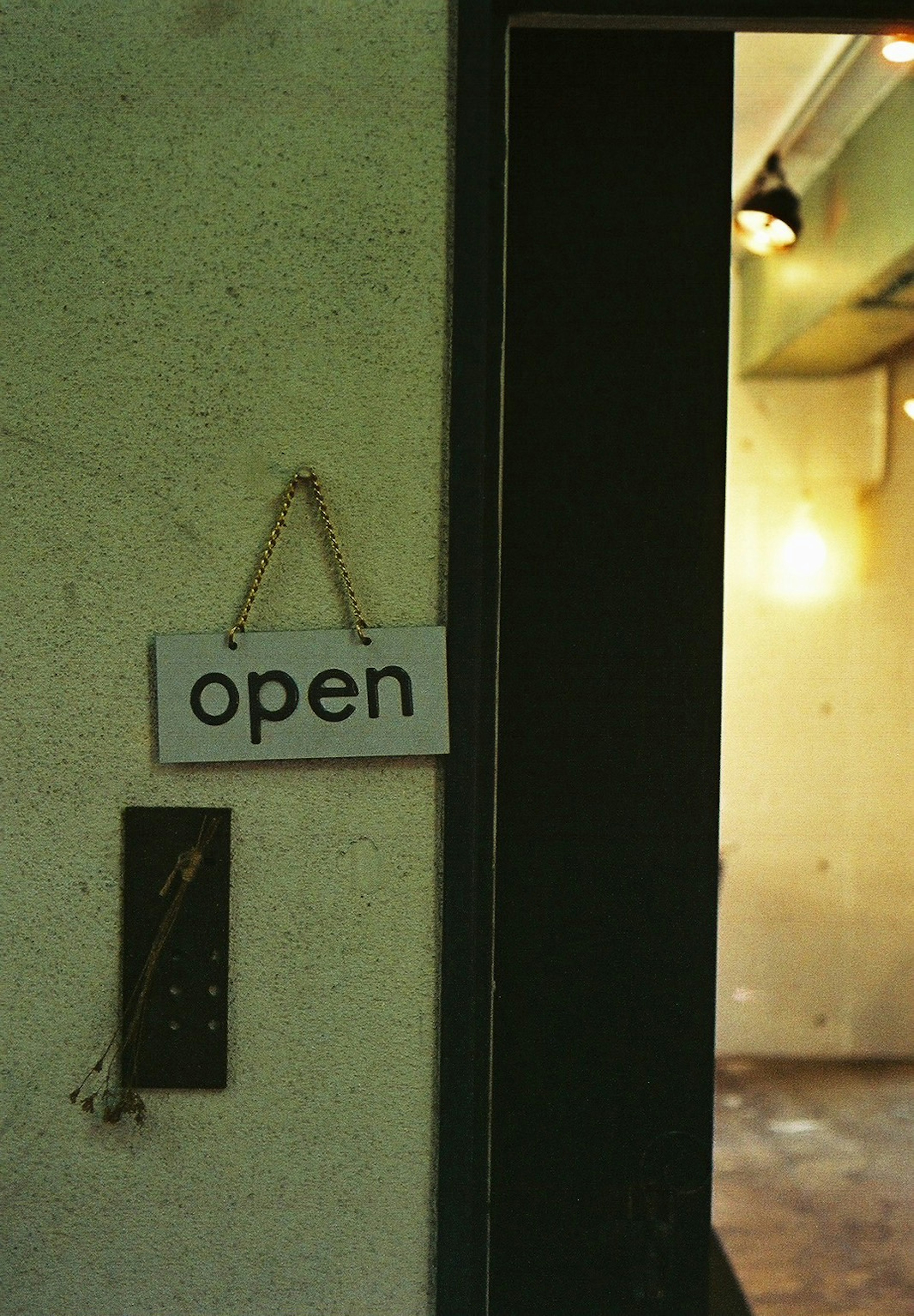 A sign that says open hanging next to a doorway