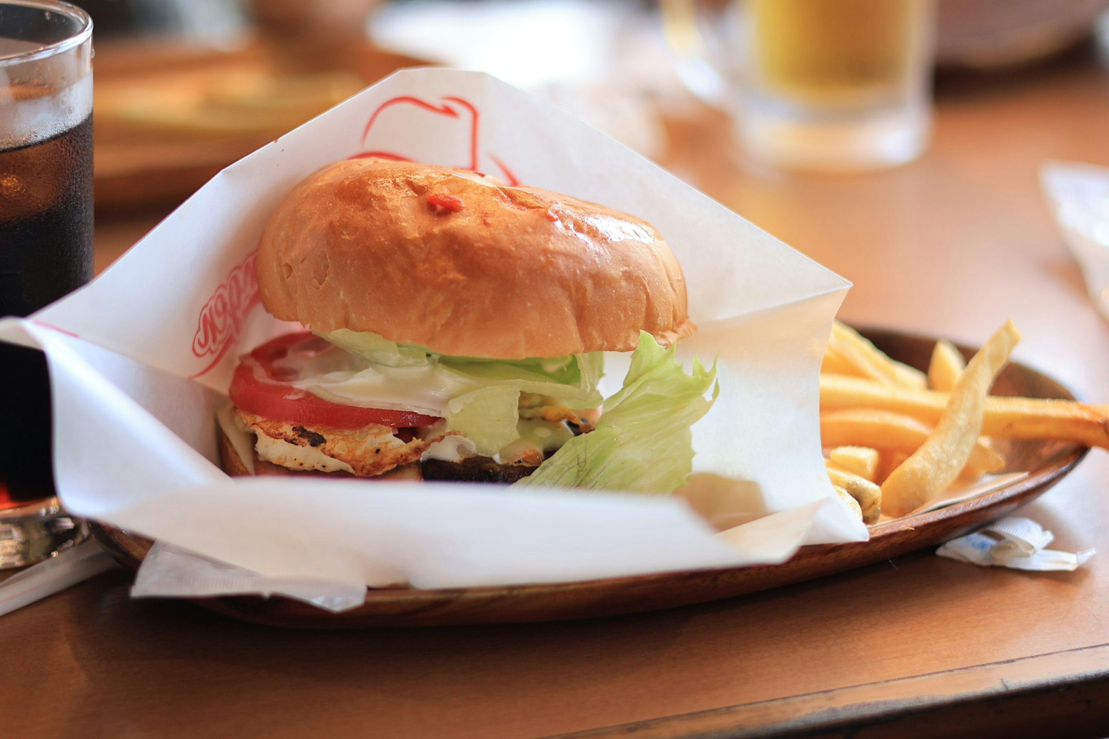 Hamburger lezat dengan selada dan tomat disajikan dengan kentang goreng