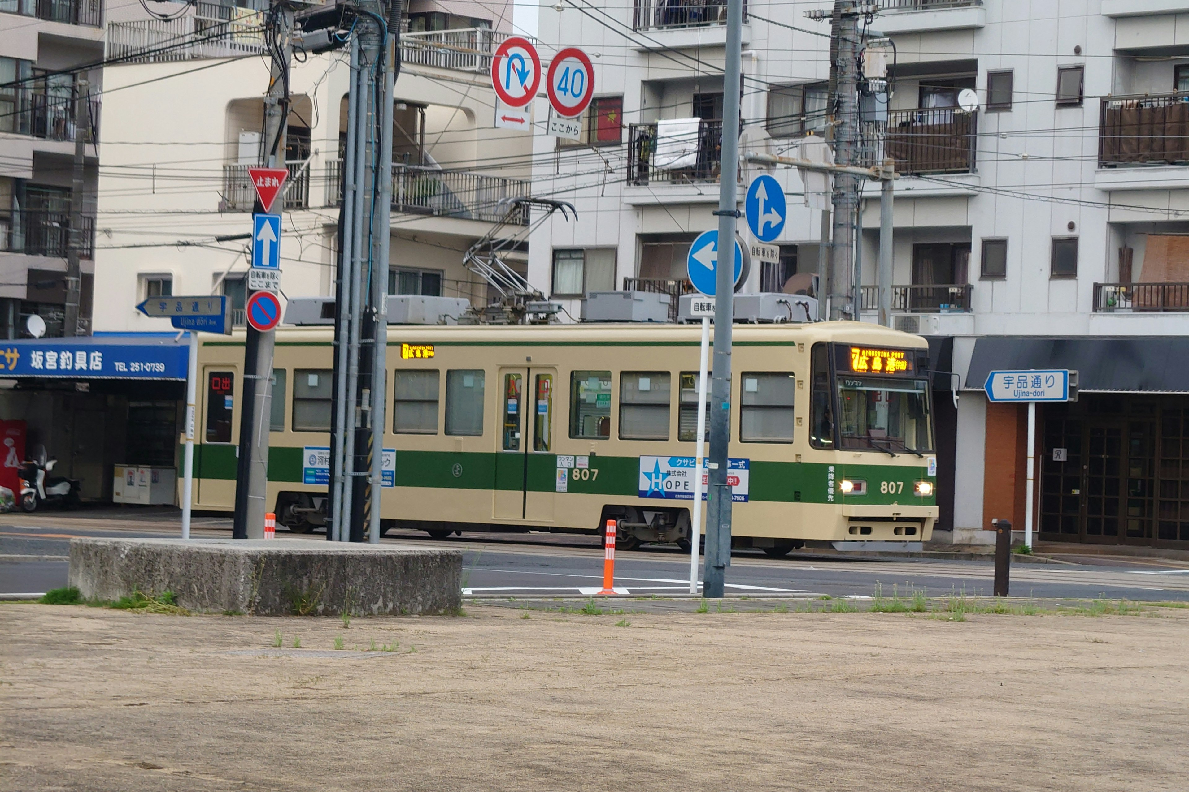 Un tramway vert et crème circulant dans une zone urbaine