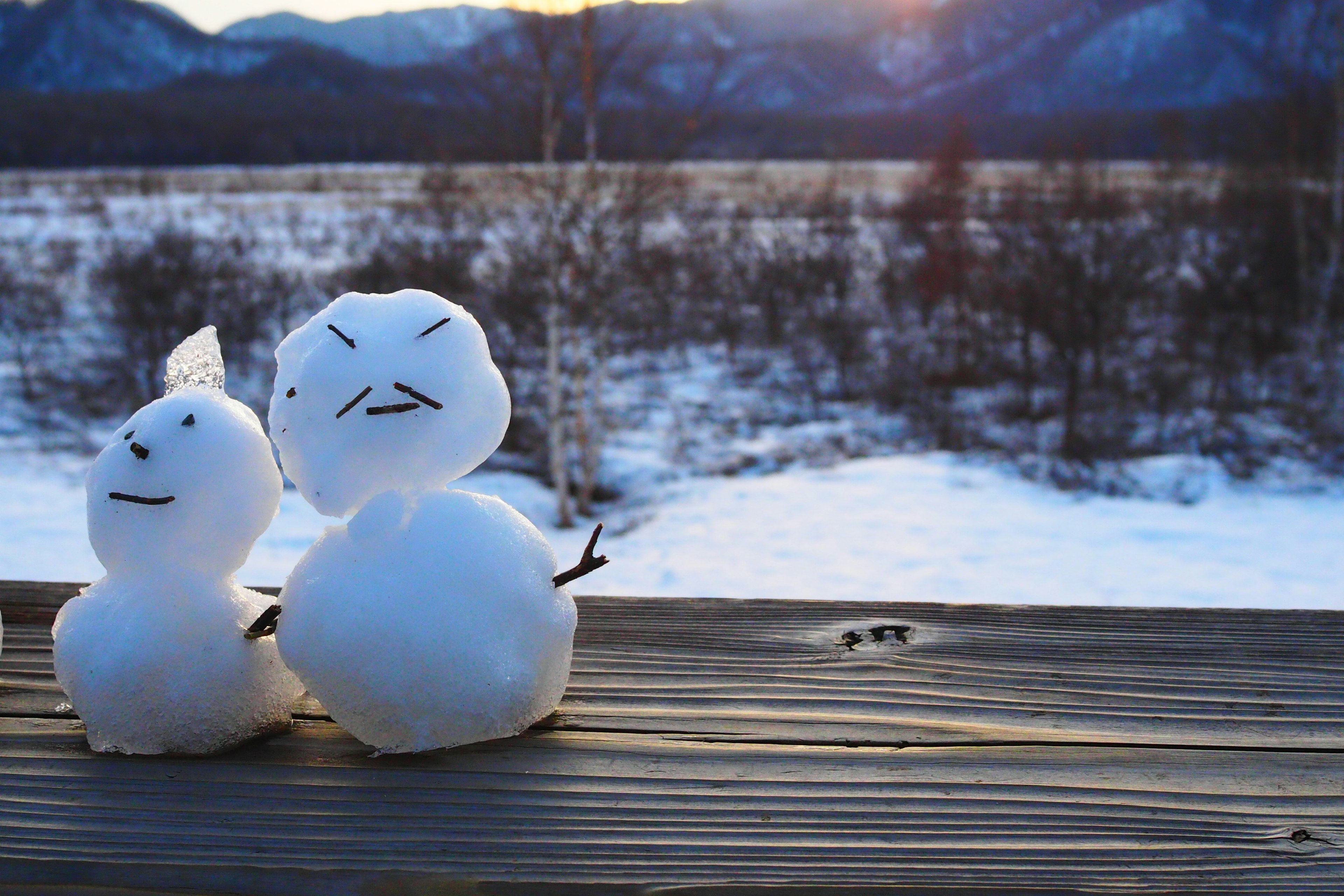 Schneemann-Paar mit einer atemberaubenden Wintersonnenuntergang-Kulisse