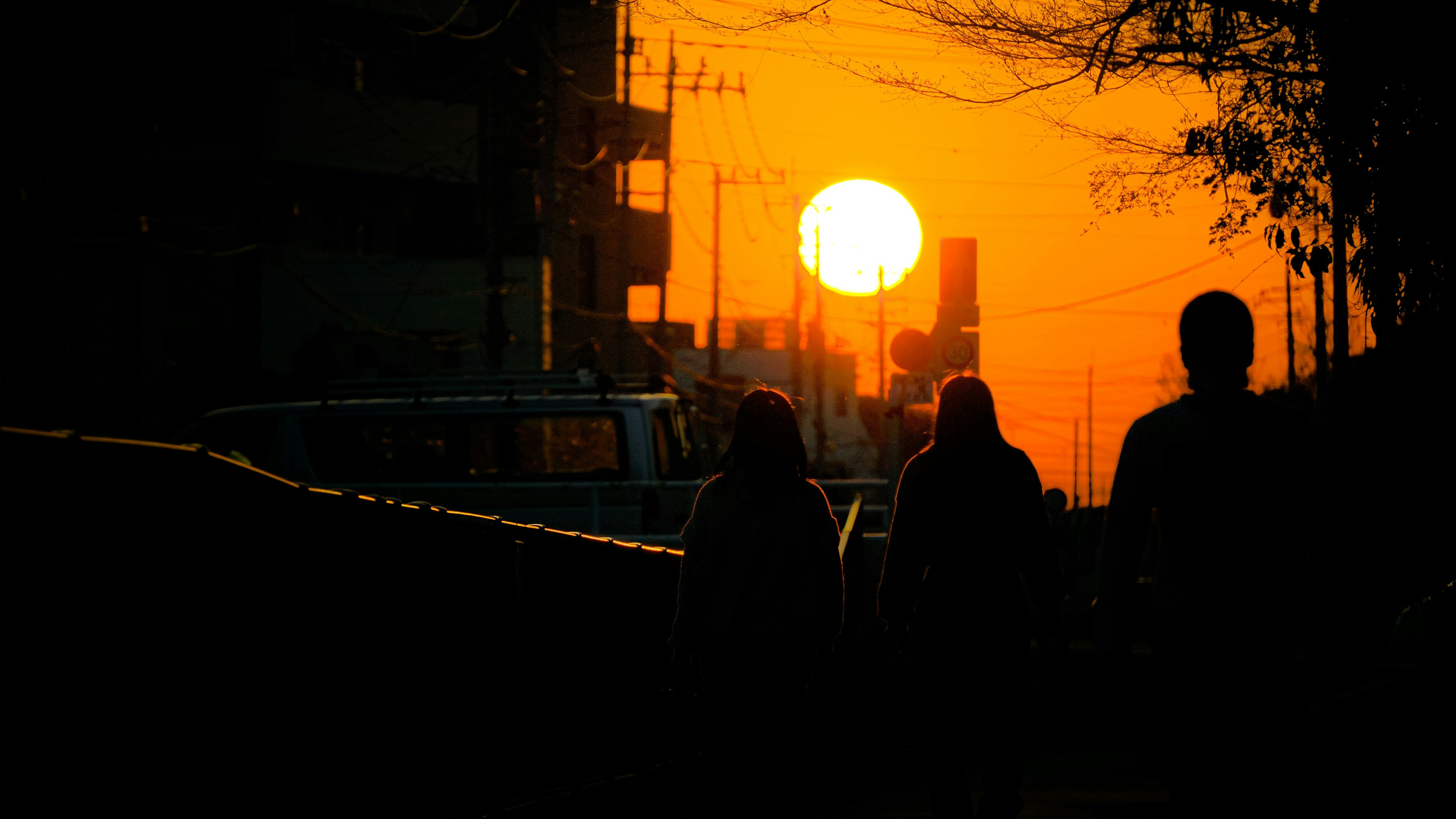 Silhouettes de personnes marchant contre un coucher de soleil