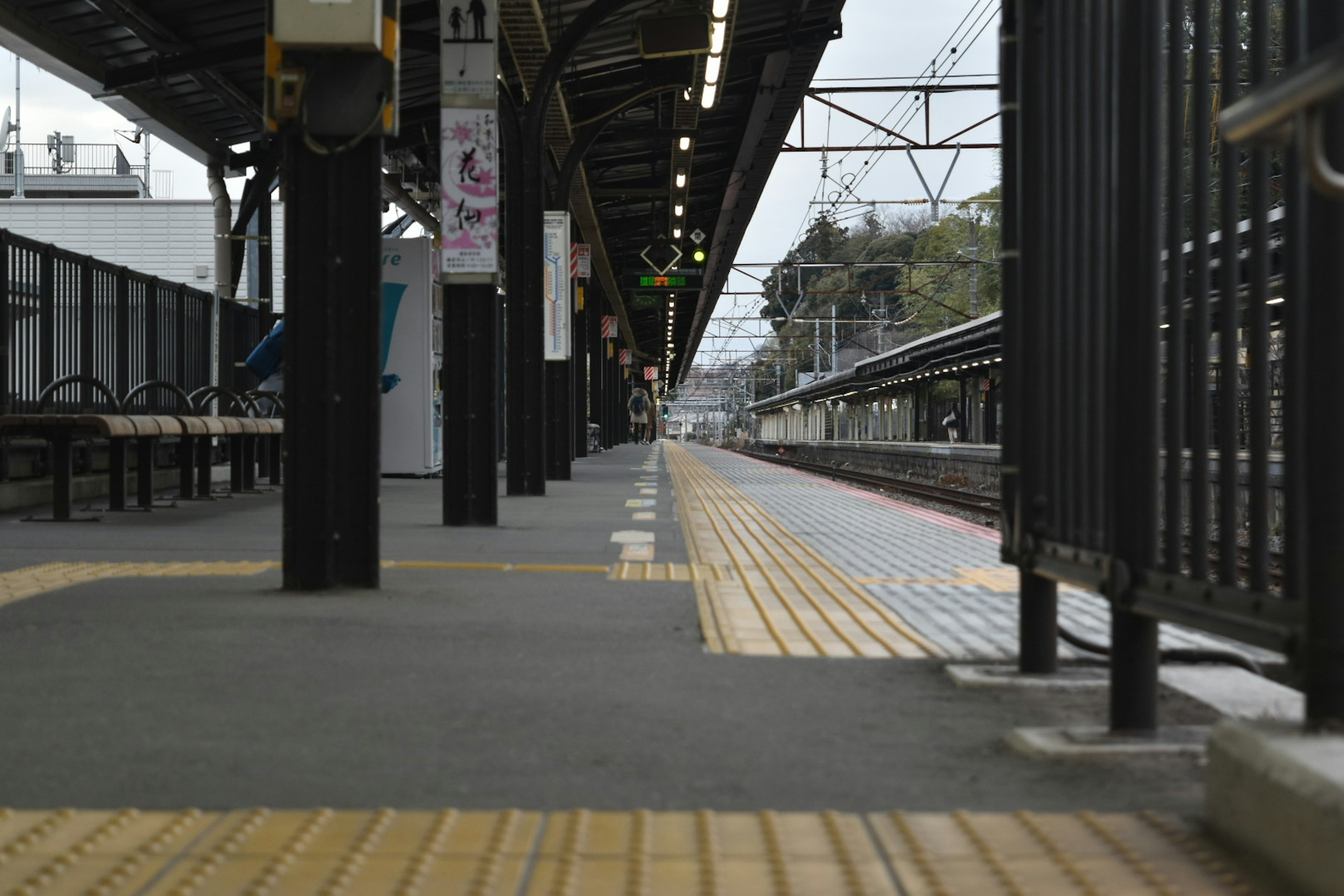 駅のプラットフォームの風景横に並んだベンチと黄色い点字ブロック