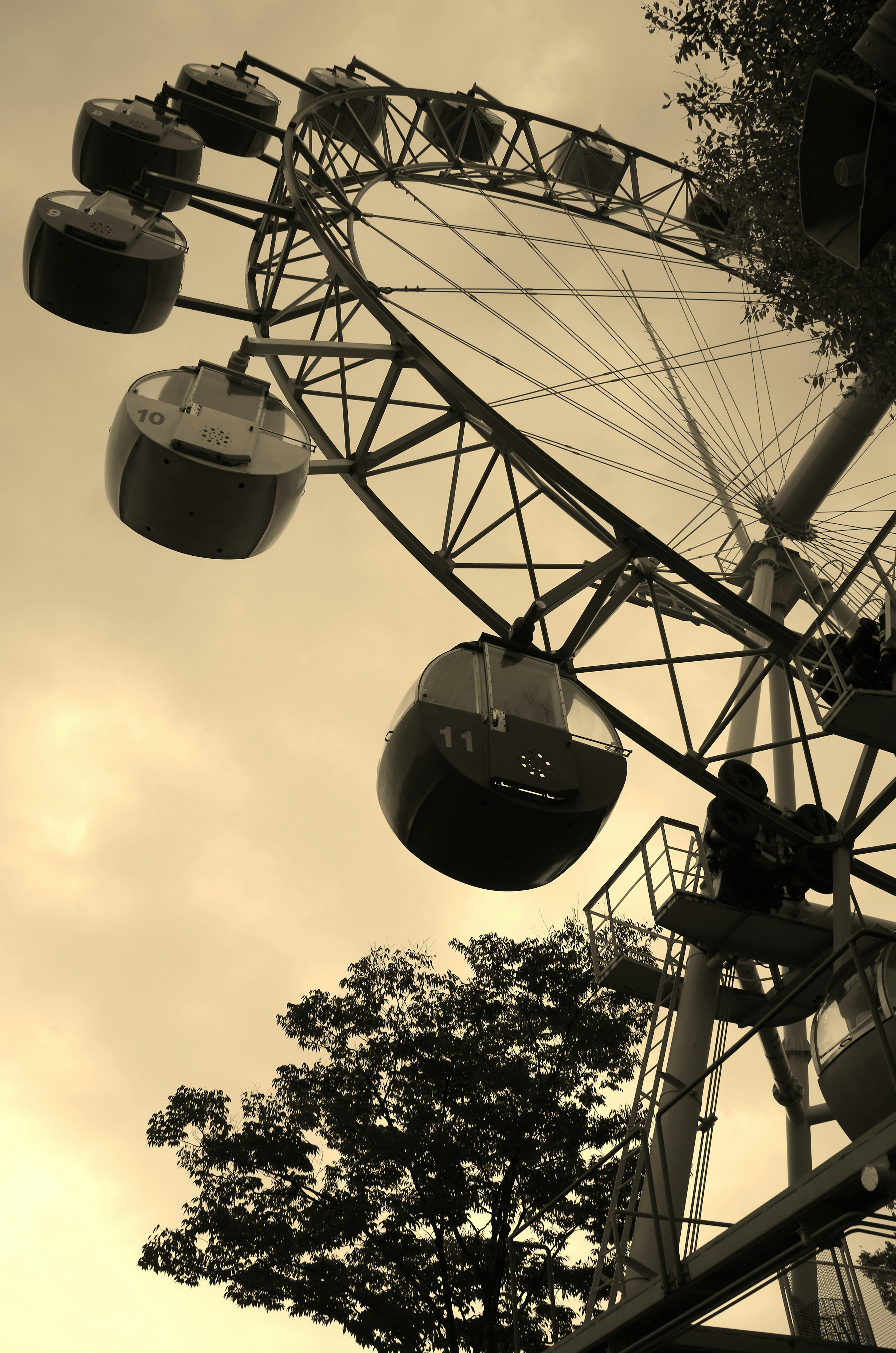 Grande roue capturée d'un angle bas avec des tons sépia et des cabines alignées