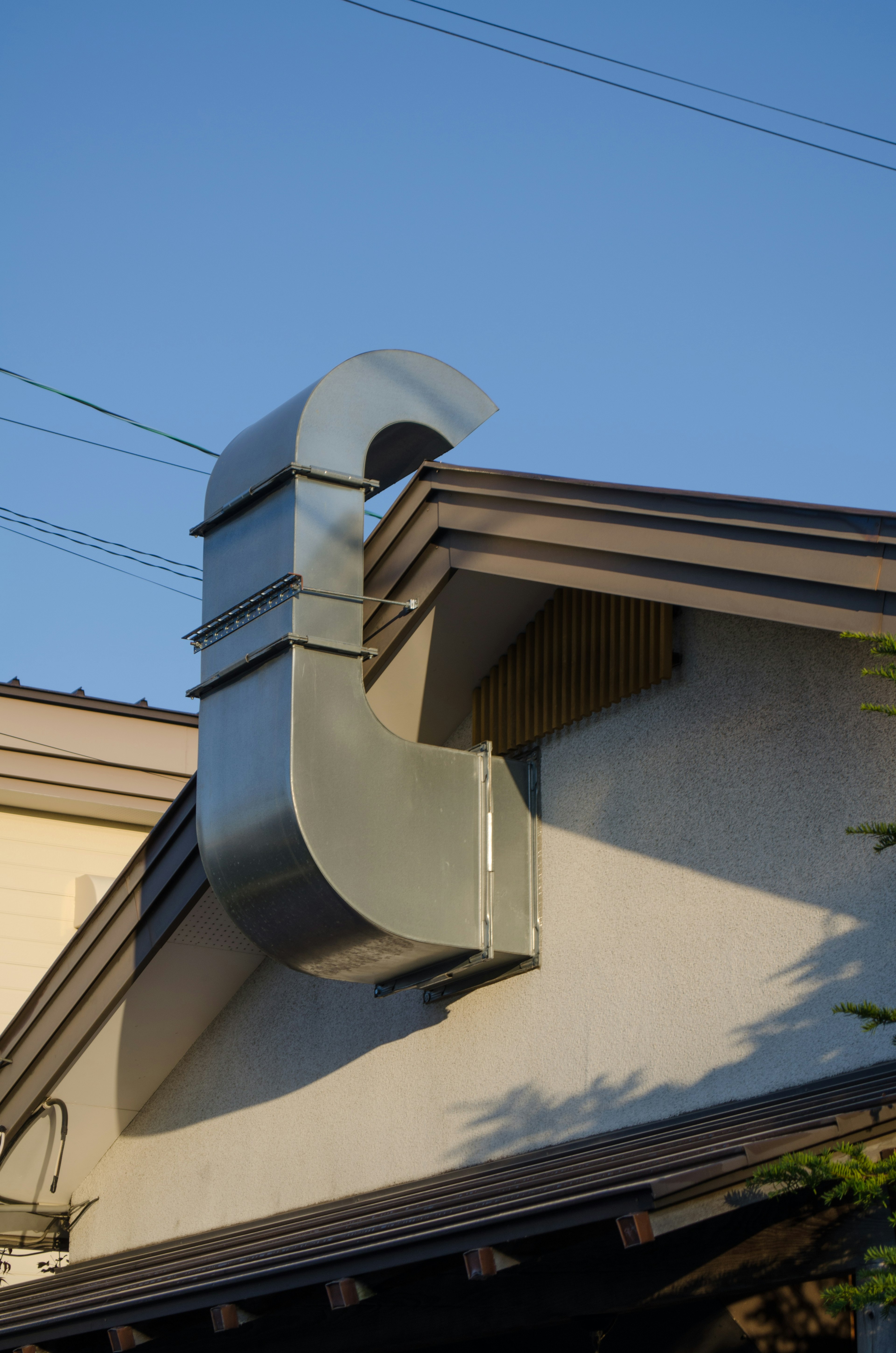 Einzigartiges Metallrohrdesign auf einem Dach vor blauem Himmel