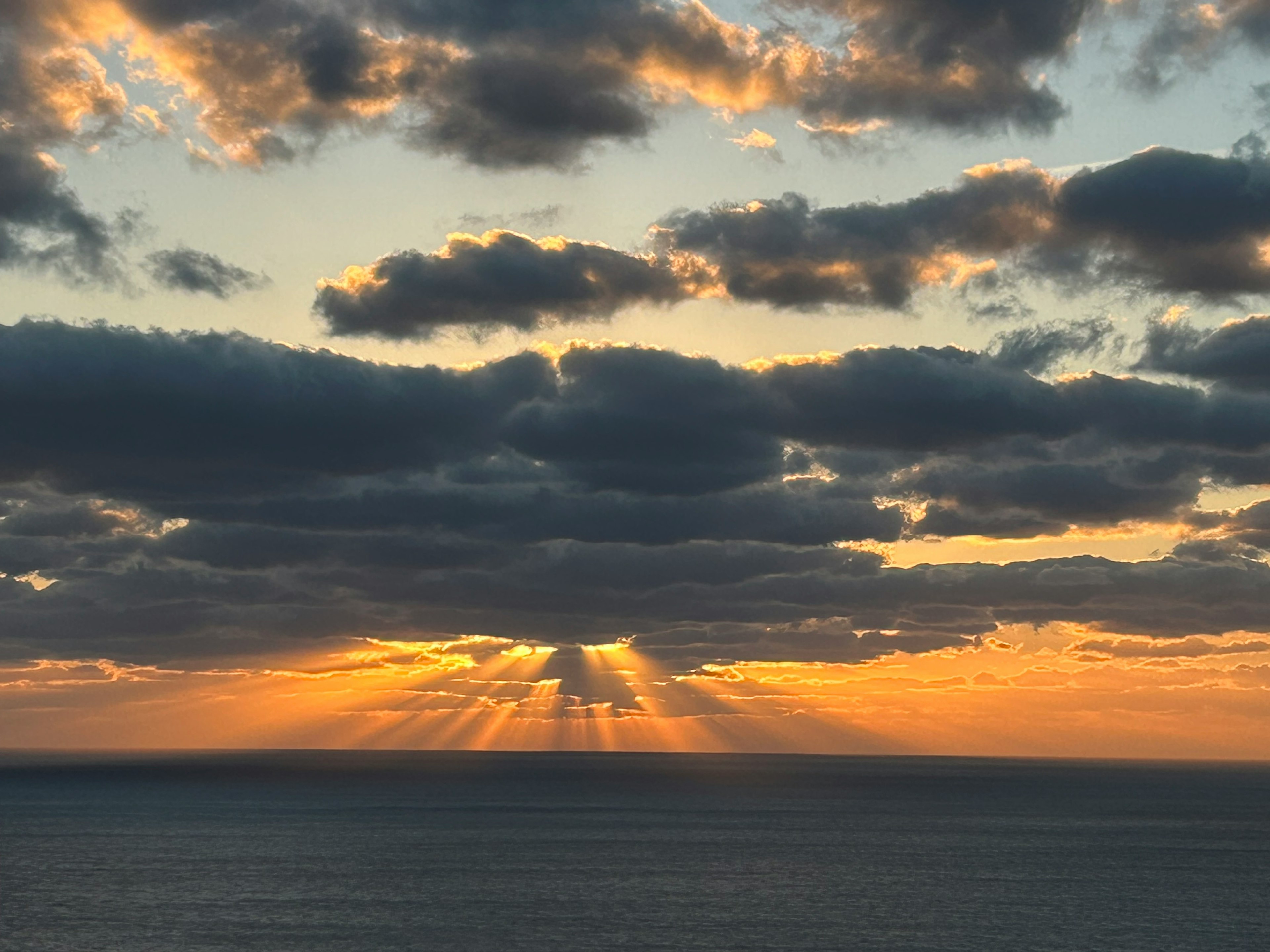 太陽が雲の間から差し込む美しい夕焼けの風景