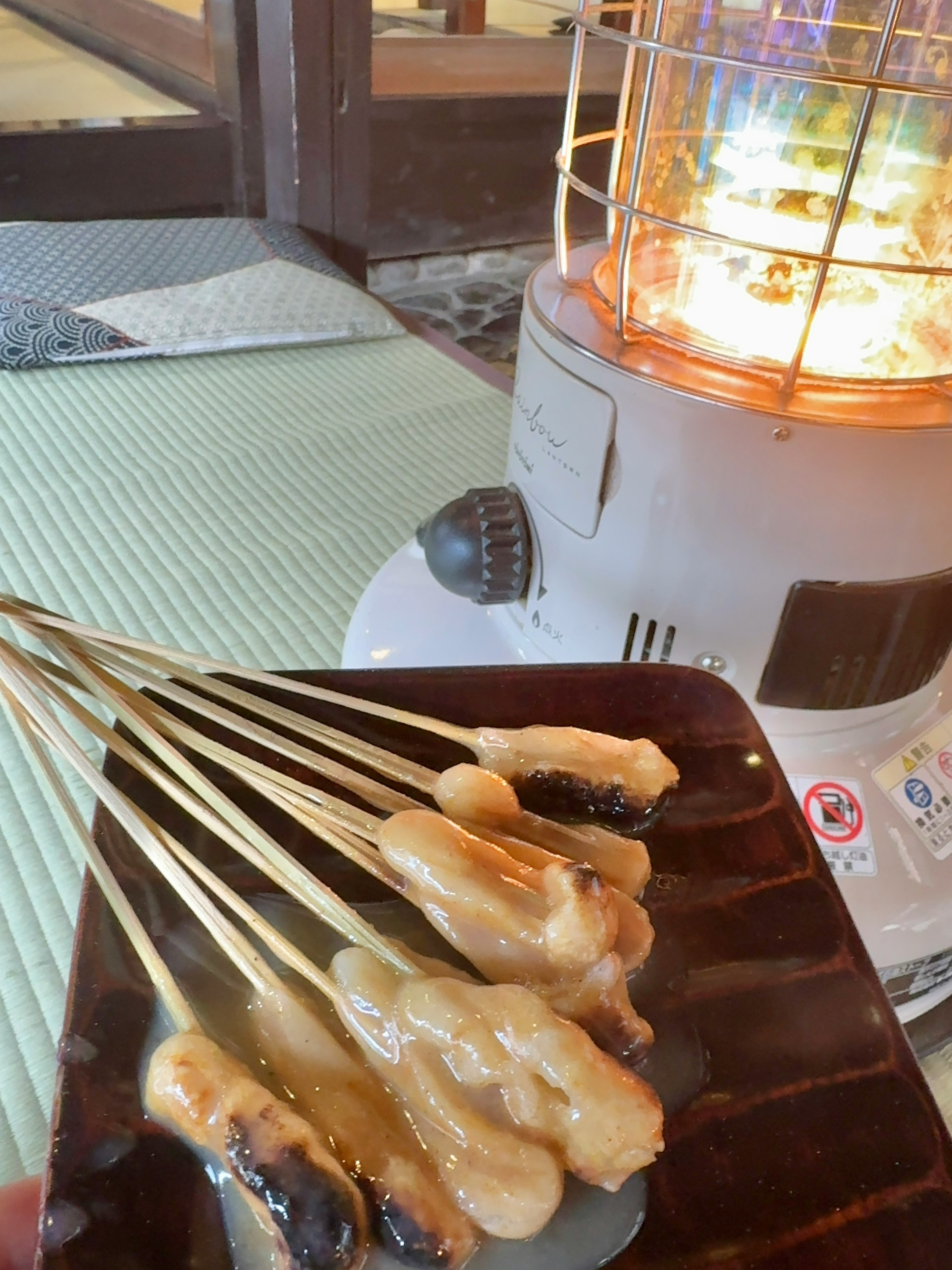 温かいストーブの近くに置かれた串焼きの皿