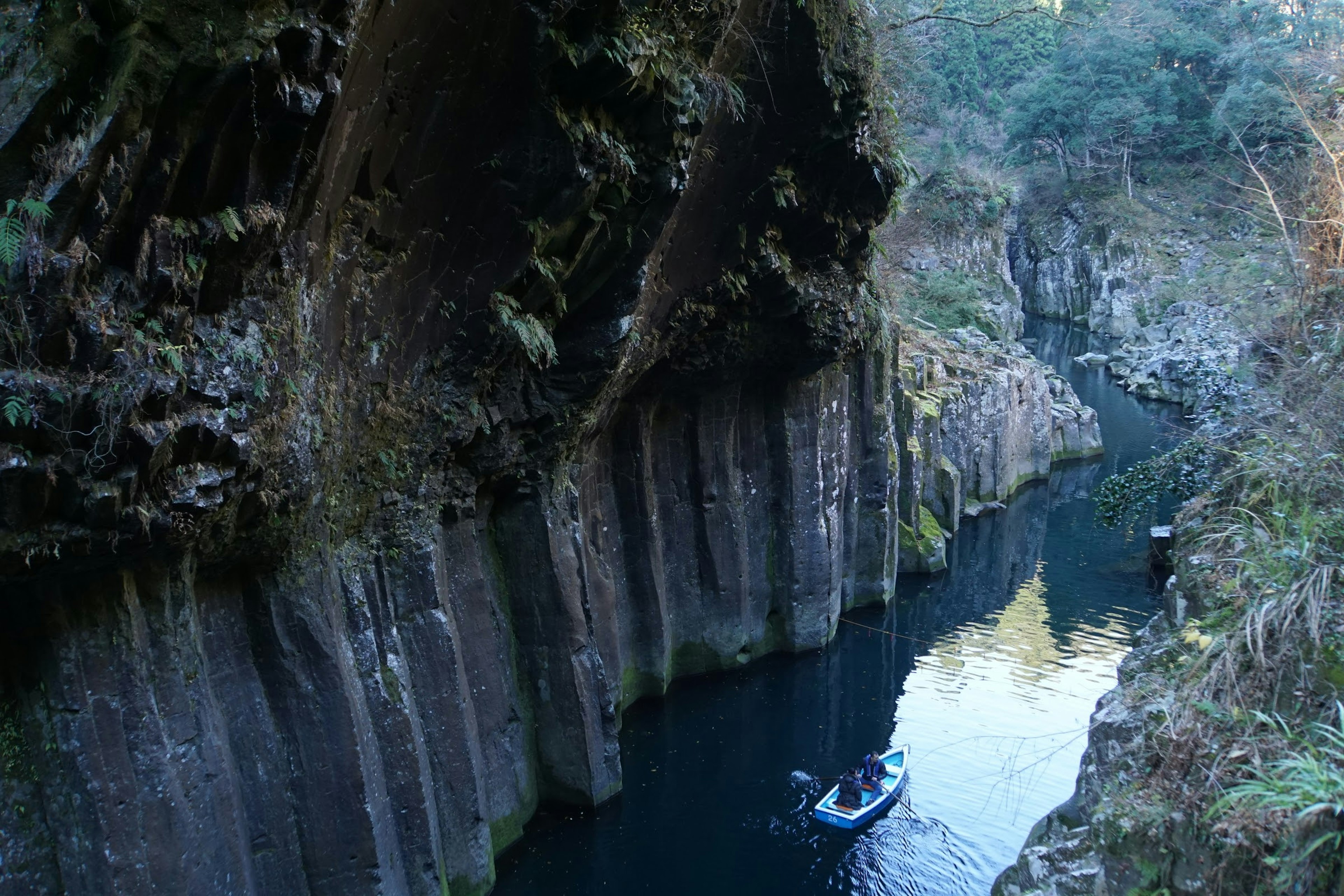 Une personne en kayak dans un profond canyon entouré de falaises rocheuses