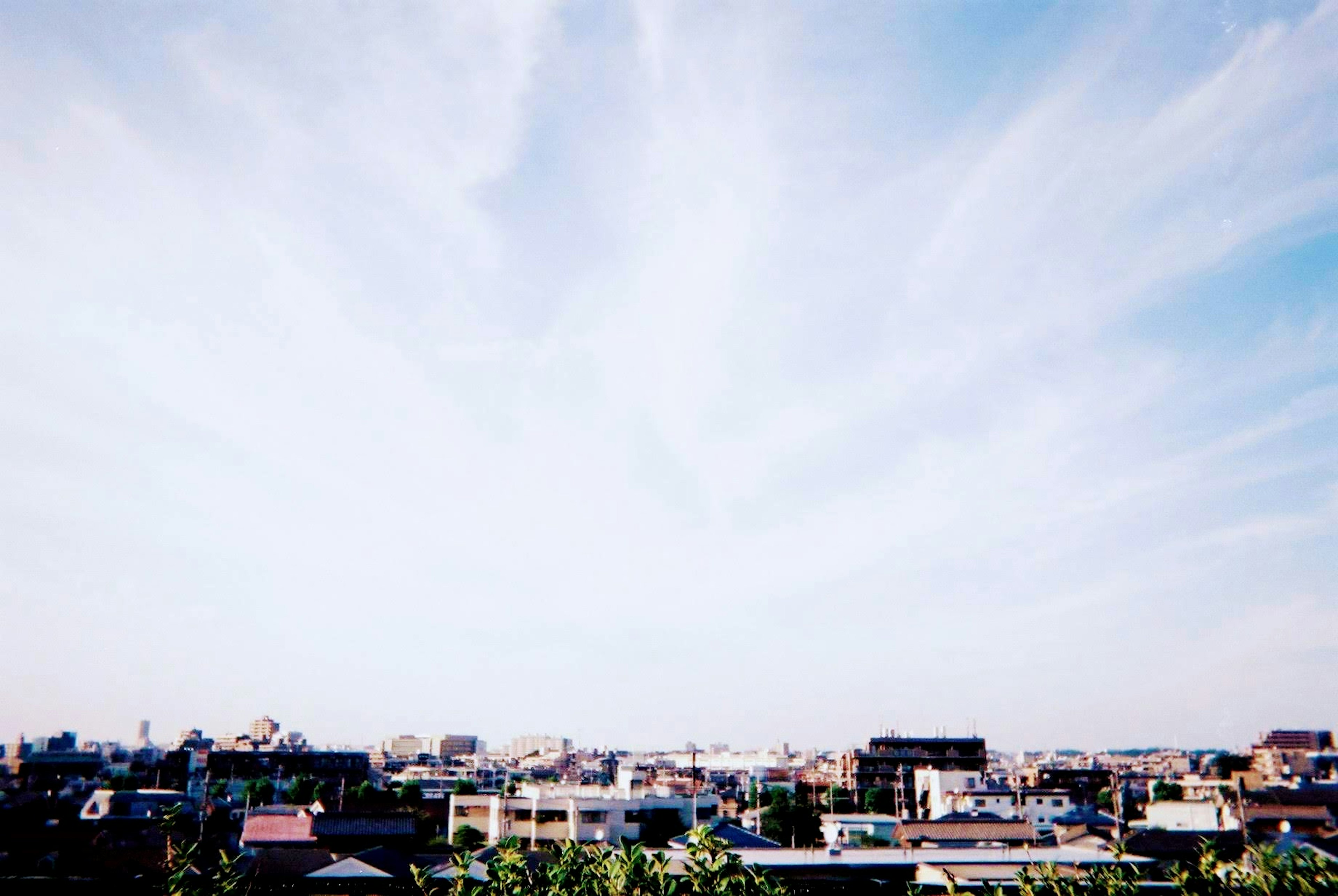 Pemandangan kota dengan langit biru cerah dan awan tipis