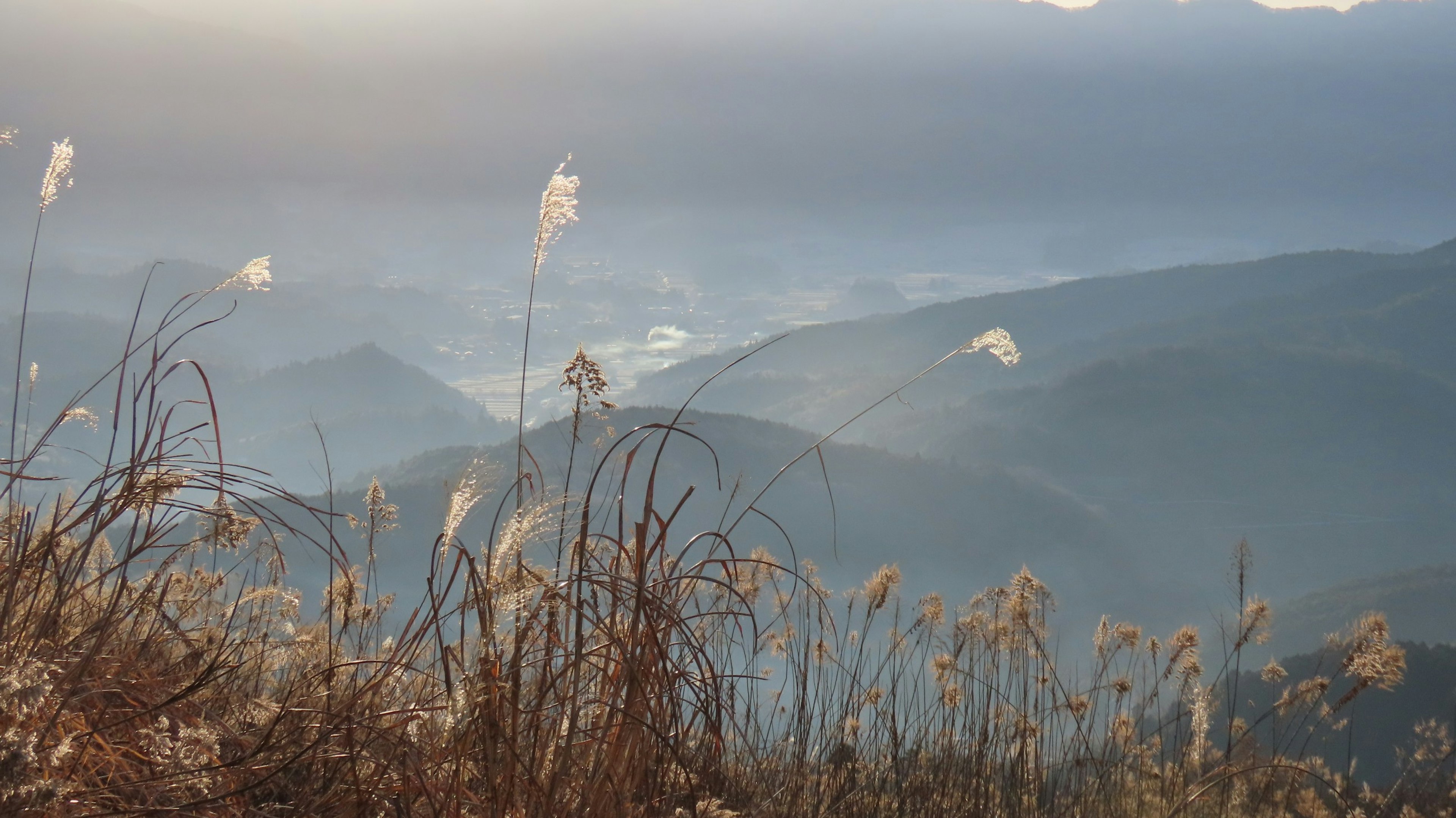 Soft light illuminating mountains and grassy landscape