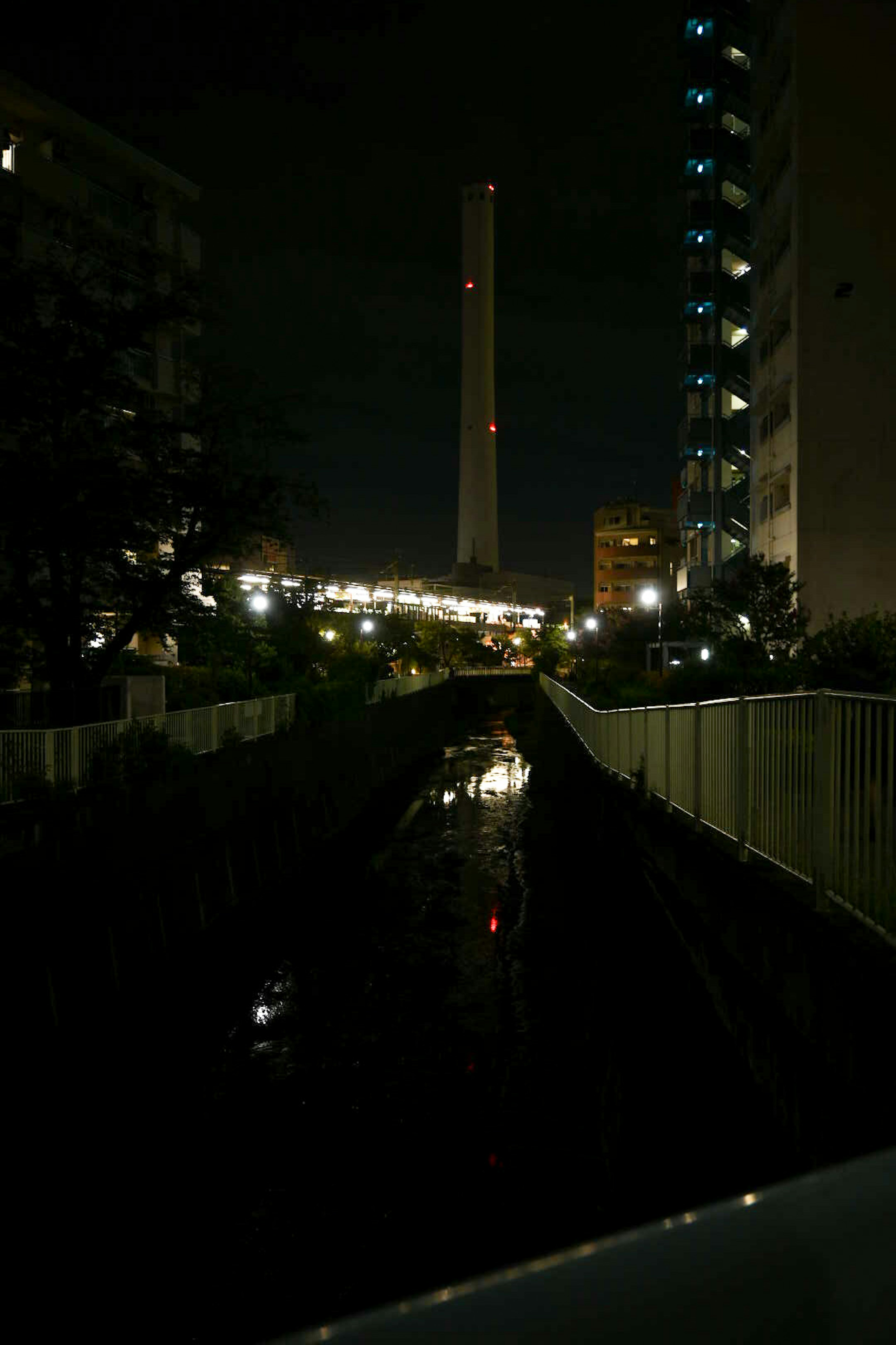 夜間城市景觀，包含煙囪和亮燈建築