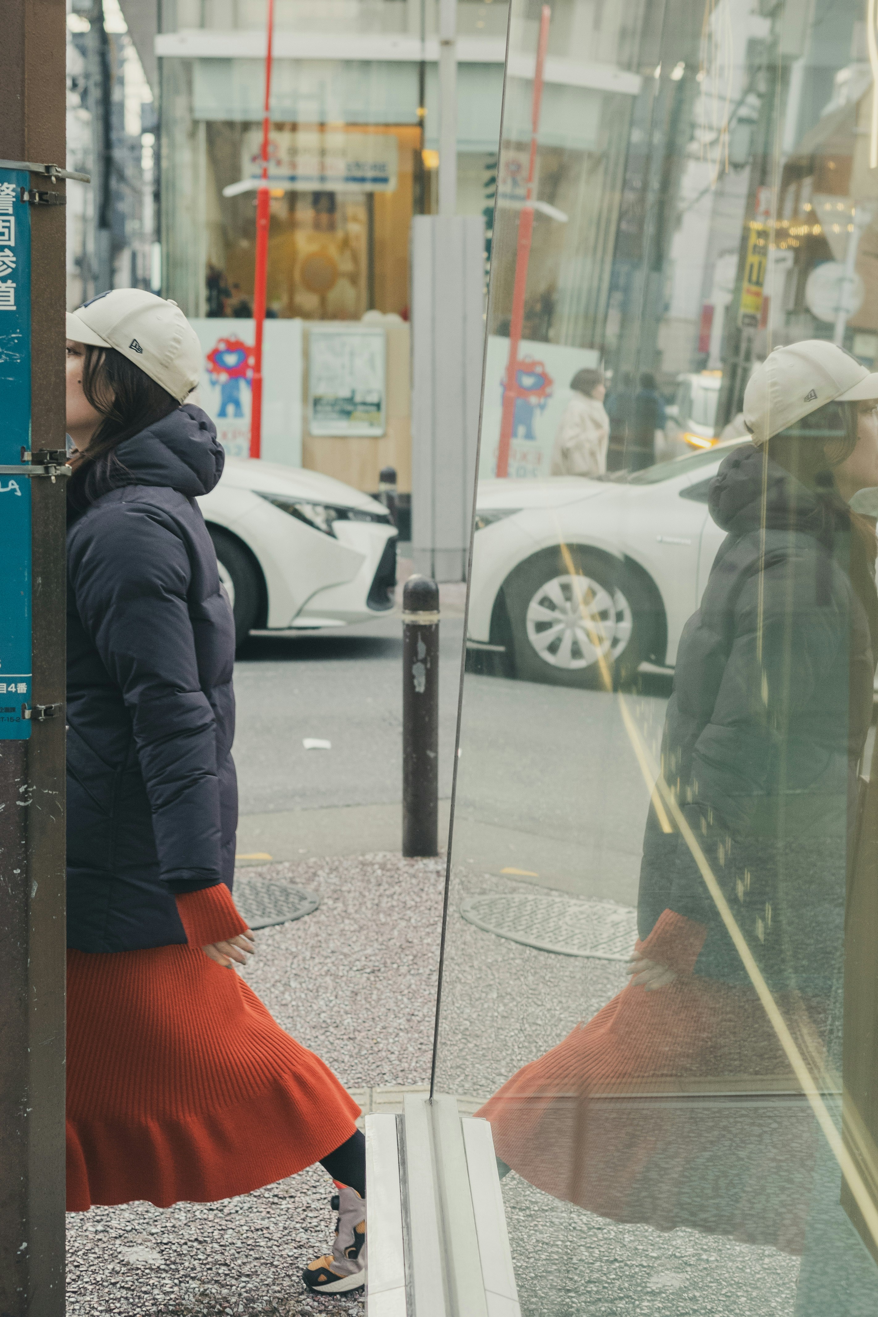 Woman in a red dress walking in the city with reflections