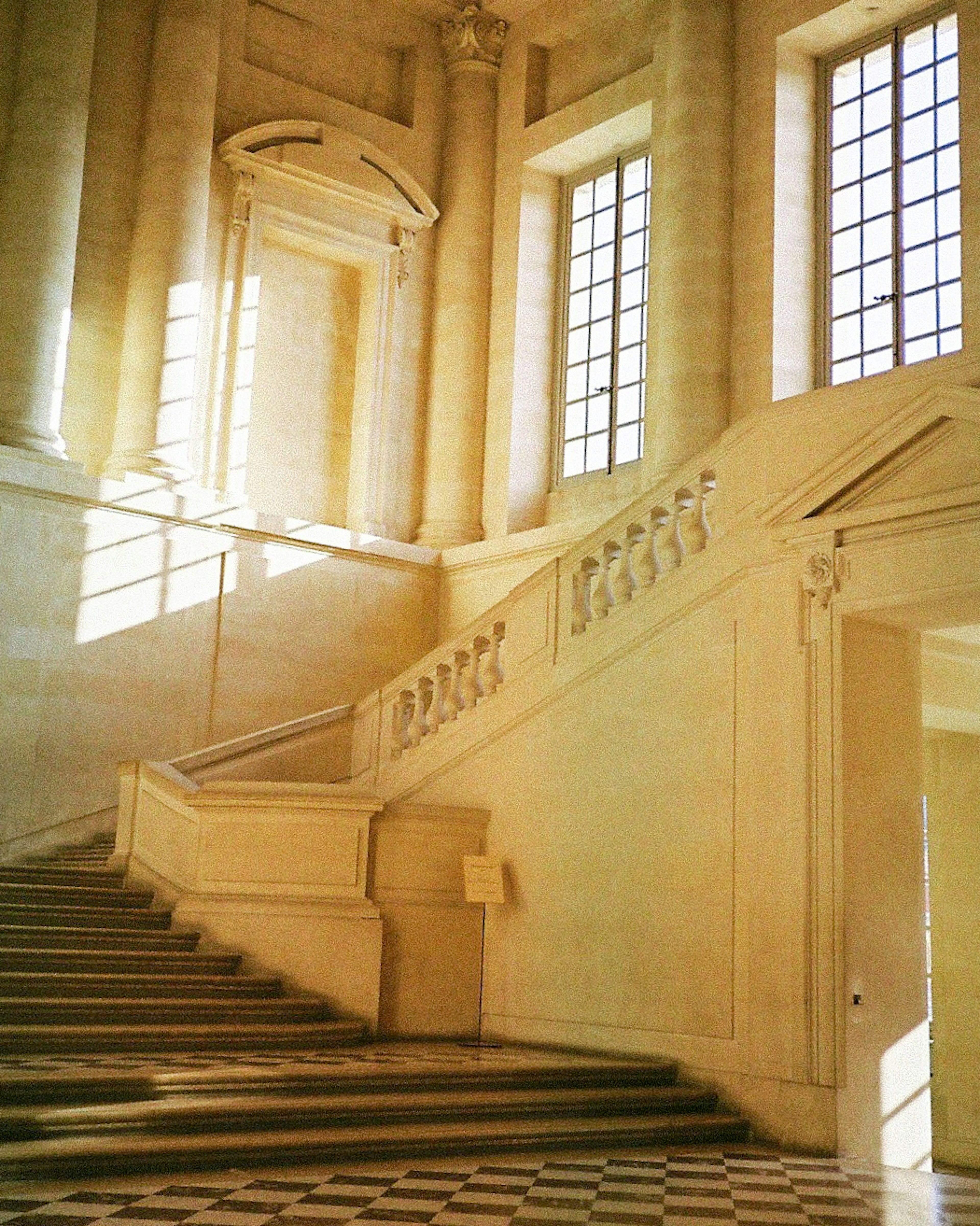 Scène intérieure lumineuse avec un bel escalier et de grandes fenêtres