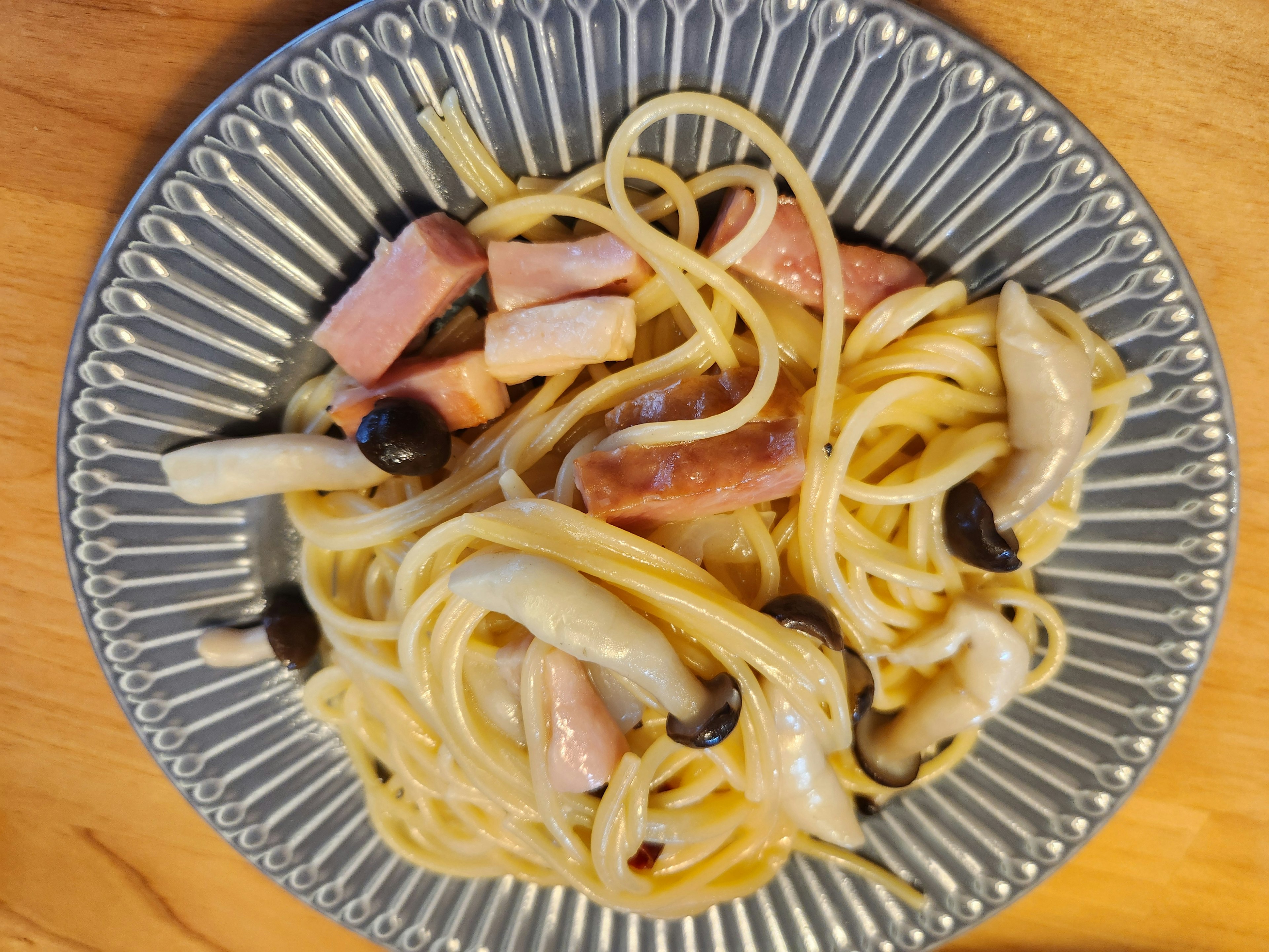 Spaghetti dengan saus krim yang ditambah ham dan jamur