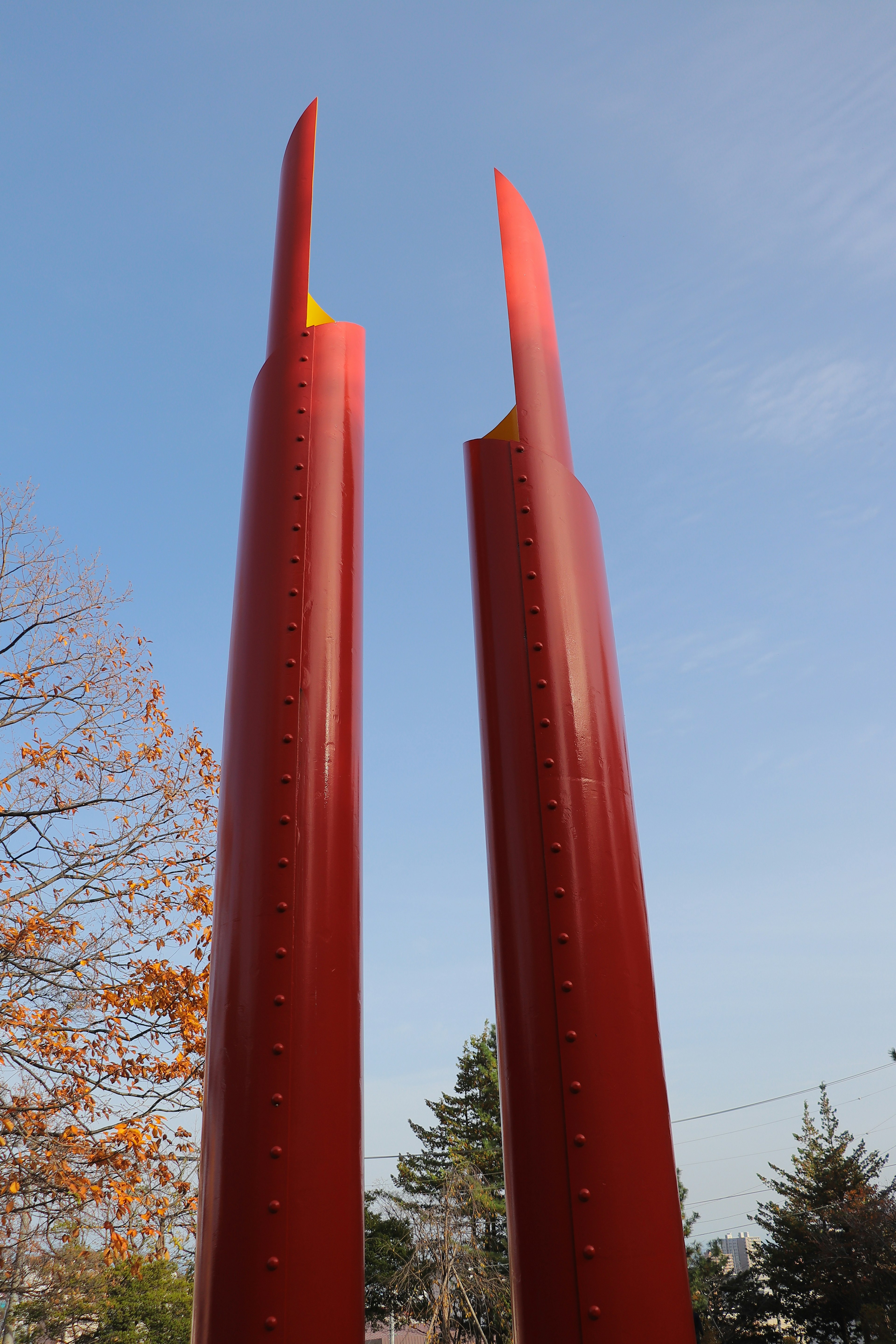 Escultura roja que se eleva hacia el cielo