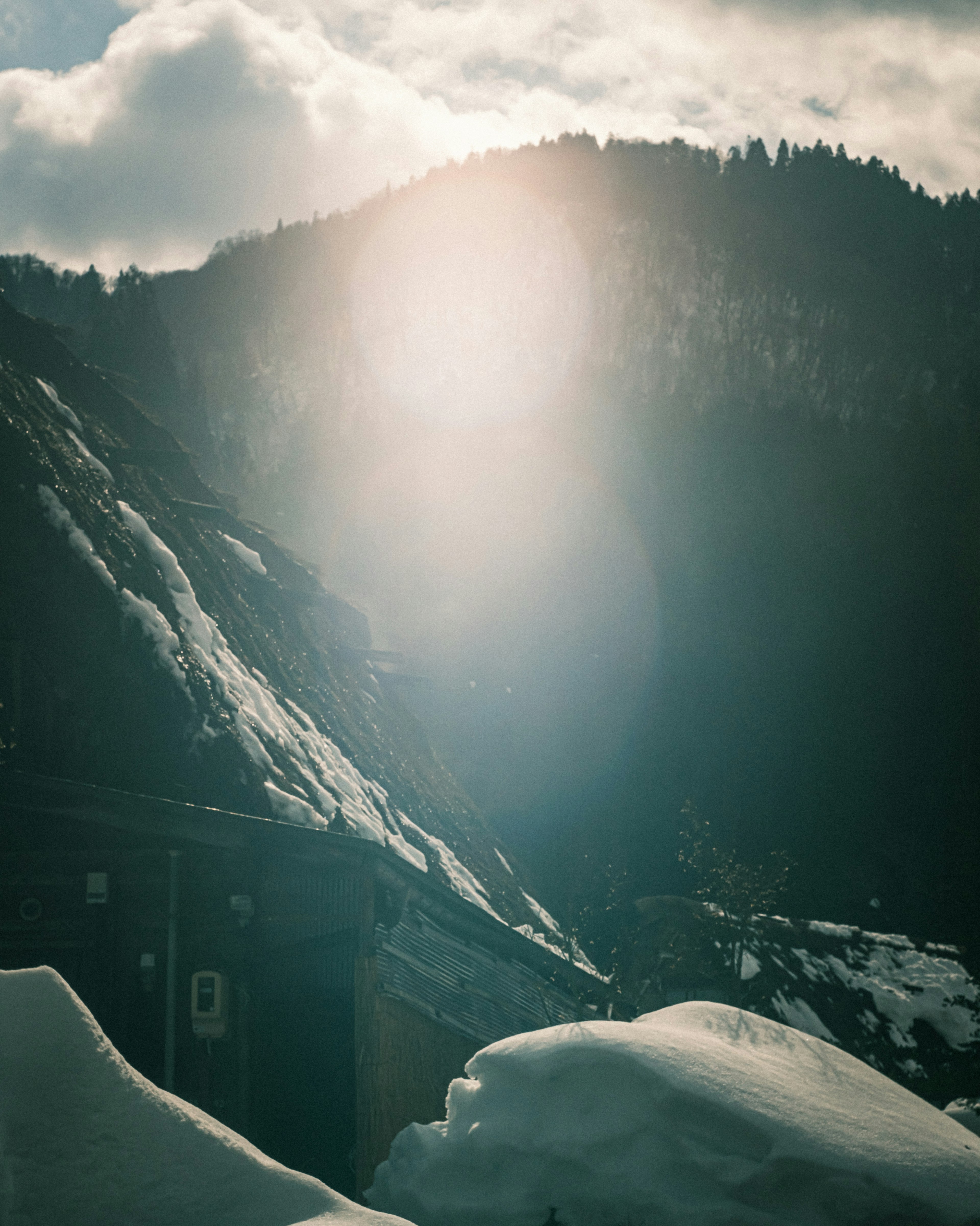 Paesaggio montano innevato con luce solare che filtra