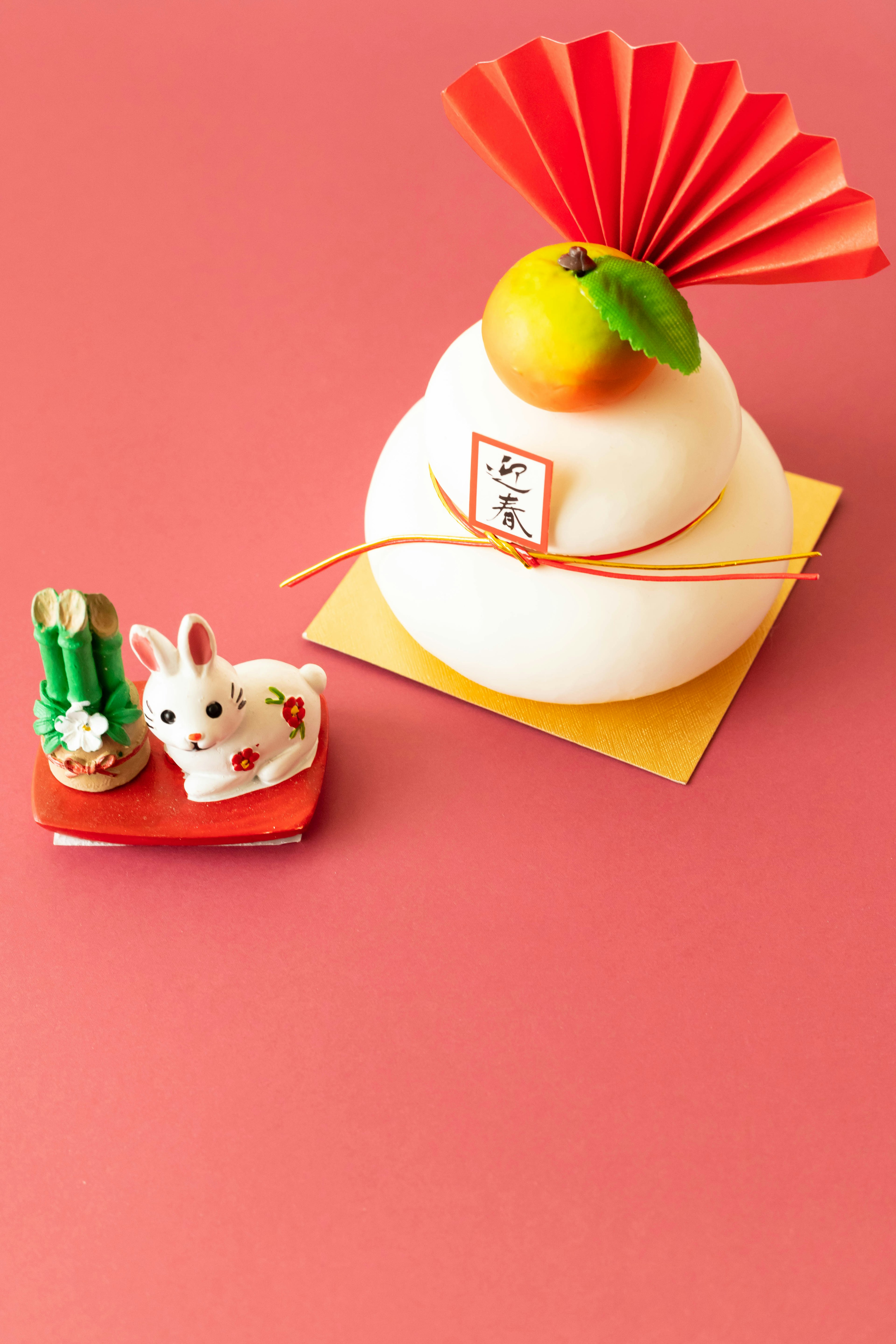 New Year decoration featuring a white rice cake with a red fan and a small rabbit figurine