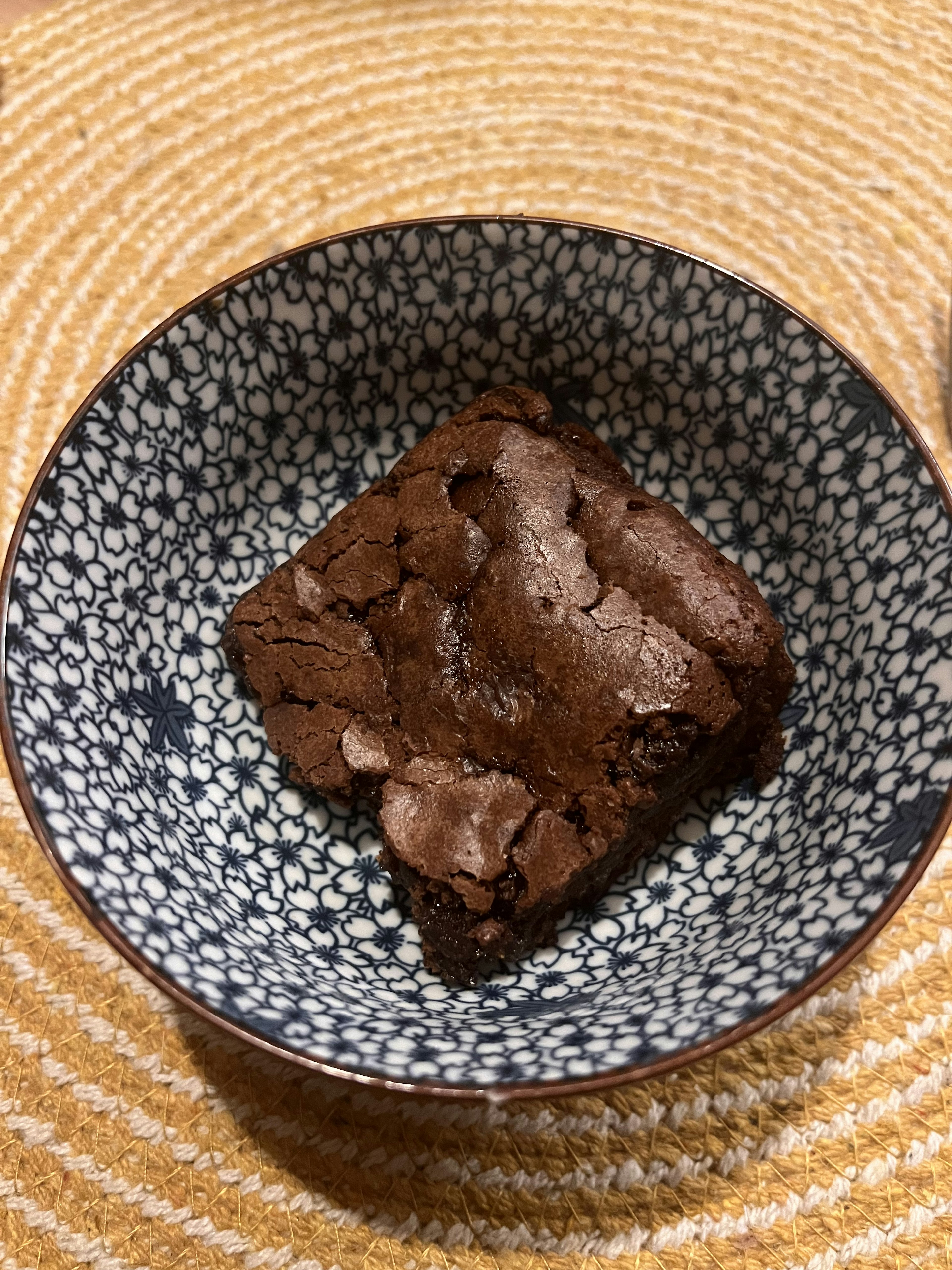 Un pezzo di brownie servito in una ciotola a motivi blu