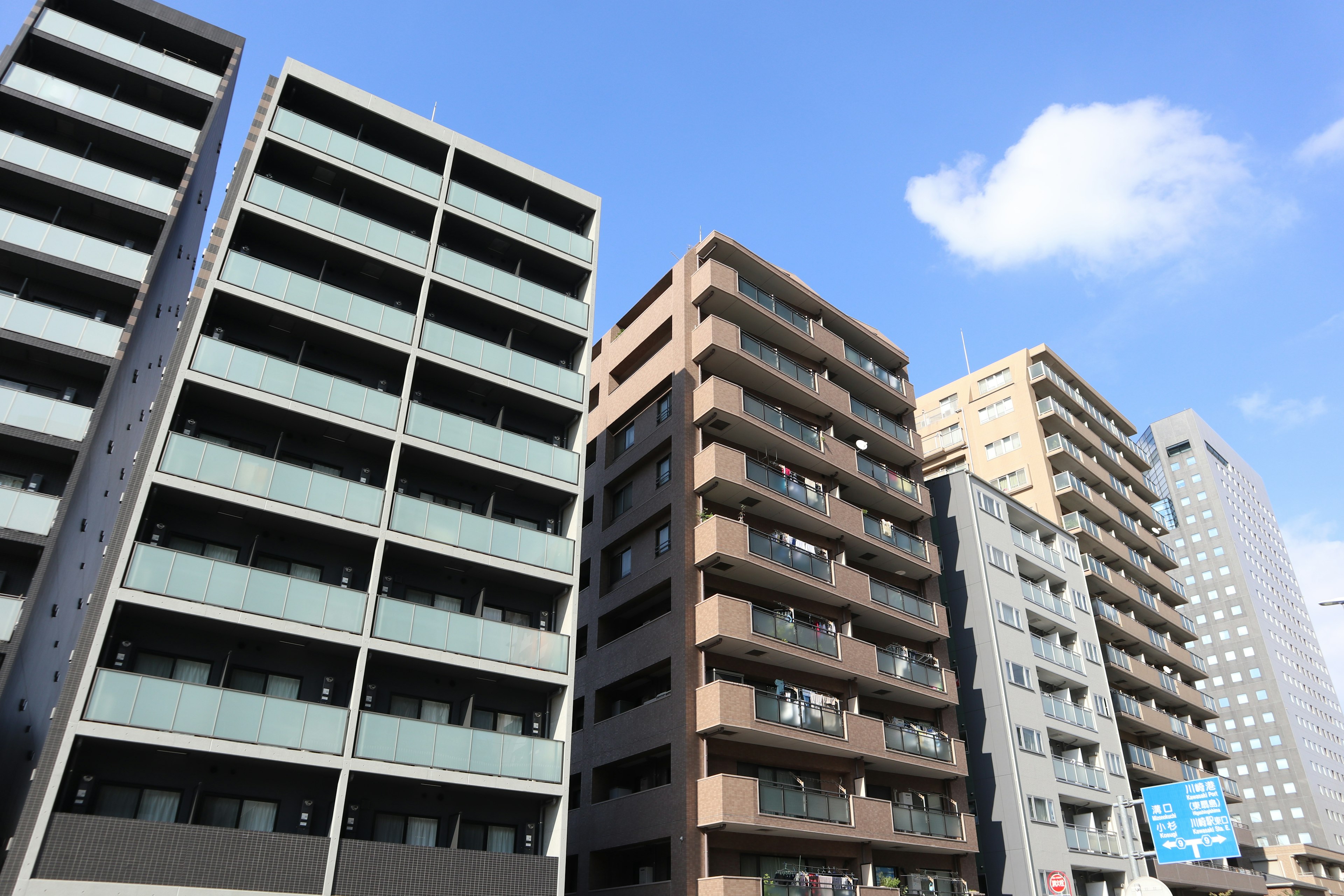 A cluster of modern apartment buildings under a blue sky