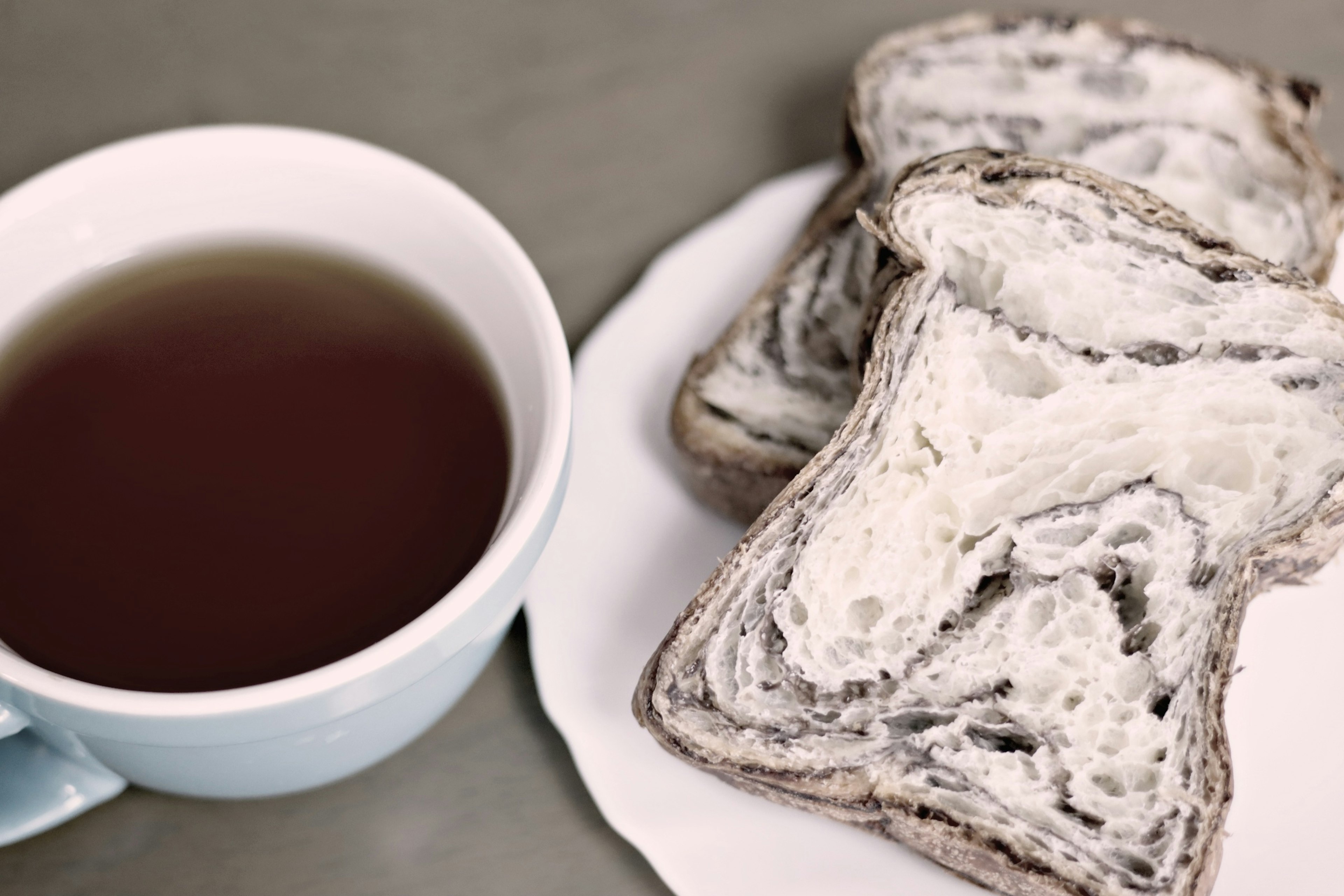 Sliced marble bread next to a cup of tea