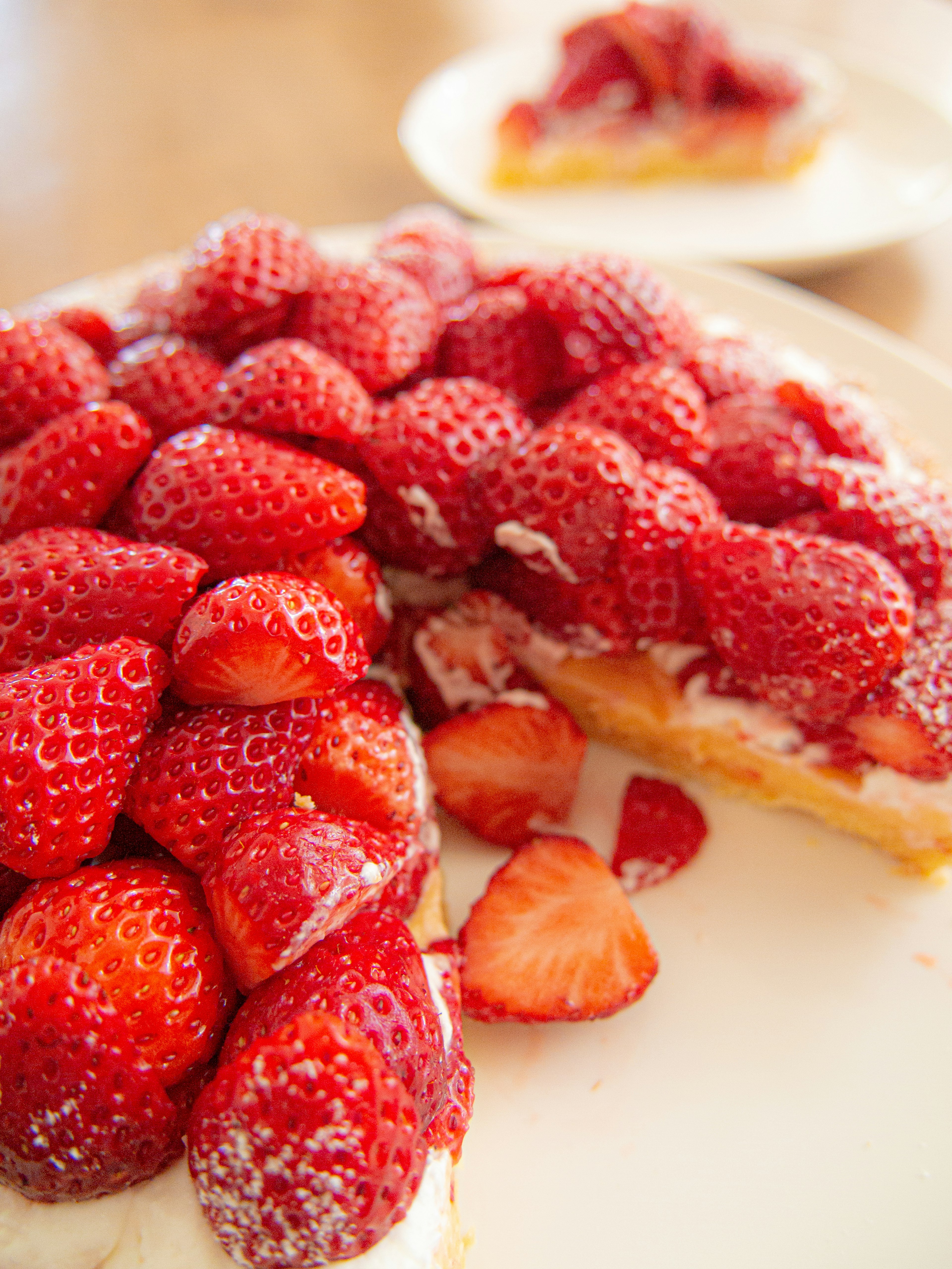 Ein geschnittener Kuchen mit frischen Erdbeeren obendrauf