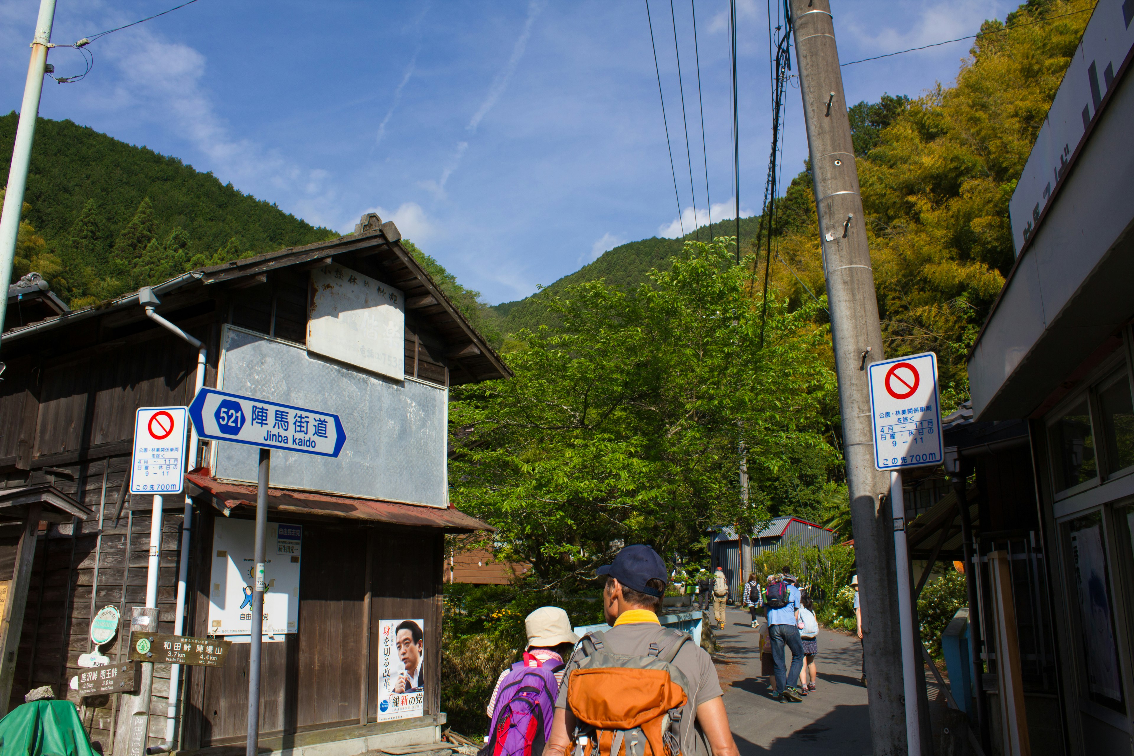 Vue pittoresque de touristes marchant le long d'une route avec des bâtiments japonais traditionnels et des montagnes verdoyantes en arrière-plan