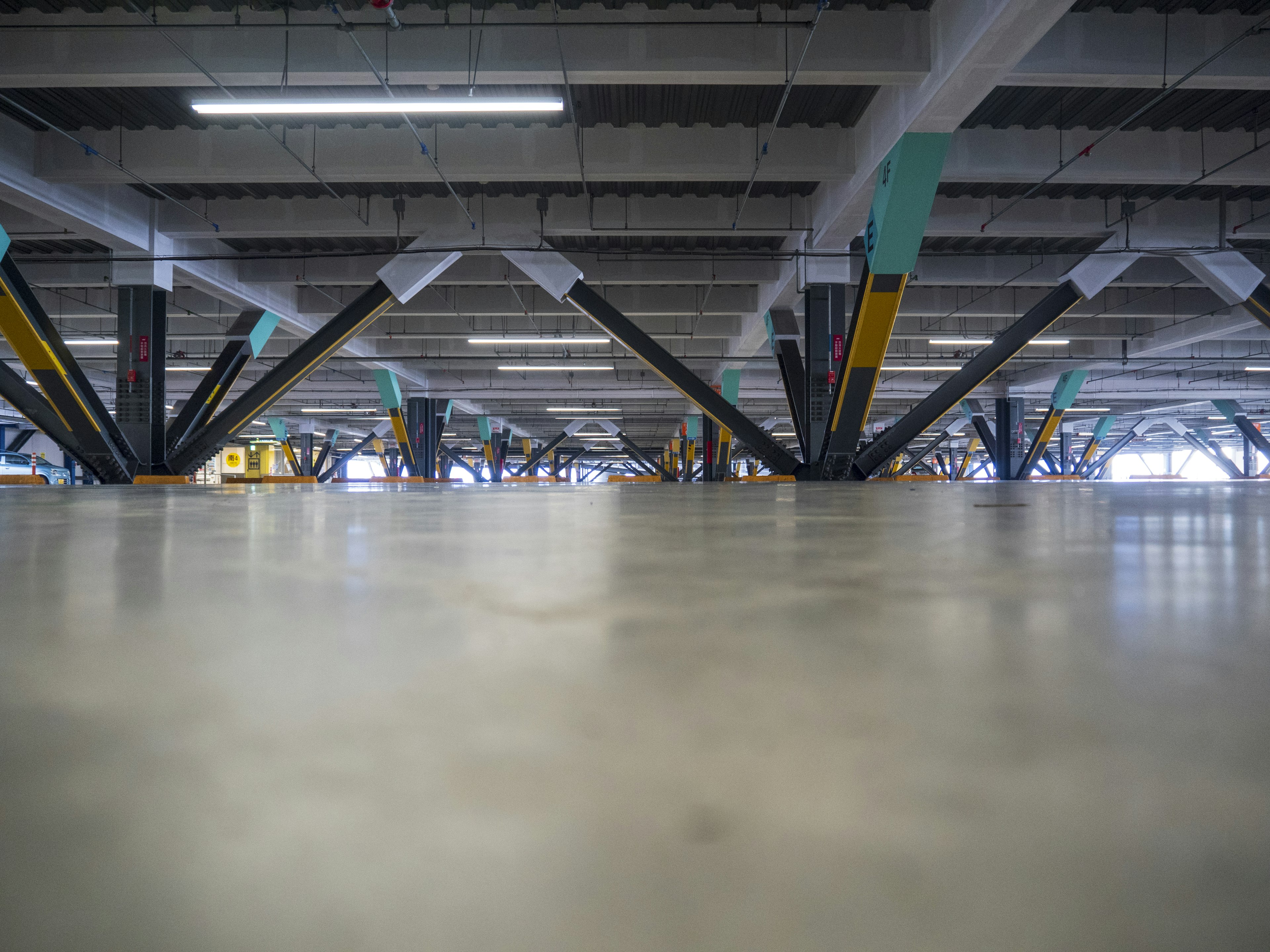 Interior view of a parking garage showing the floor and structural beams