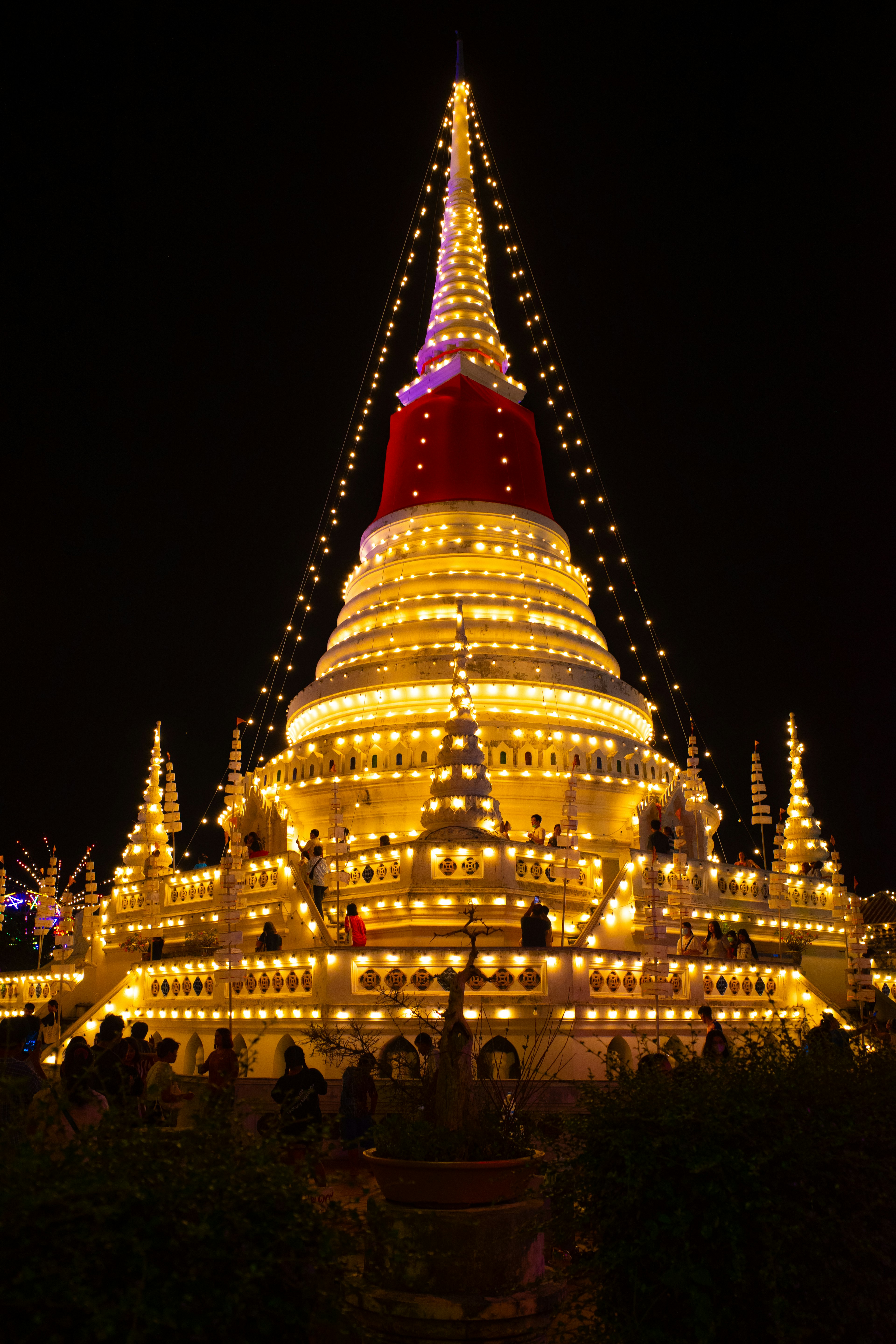 Beautifully illuminated stupa at night with decorative lights