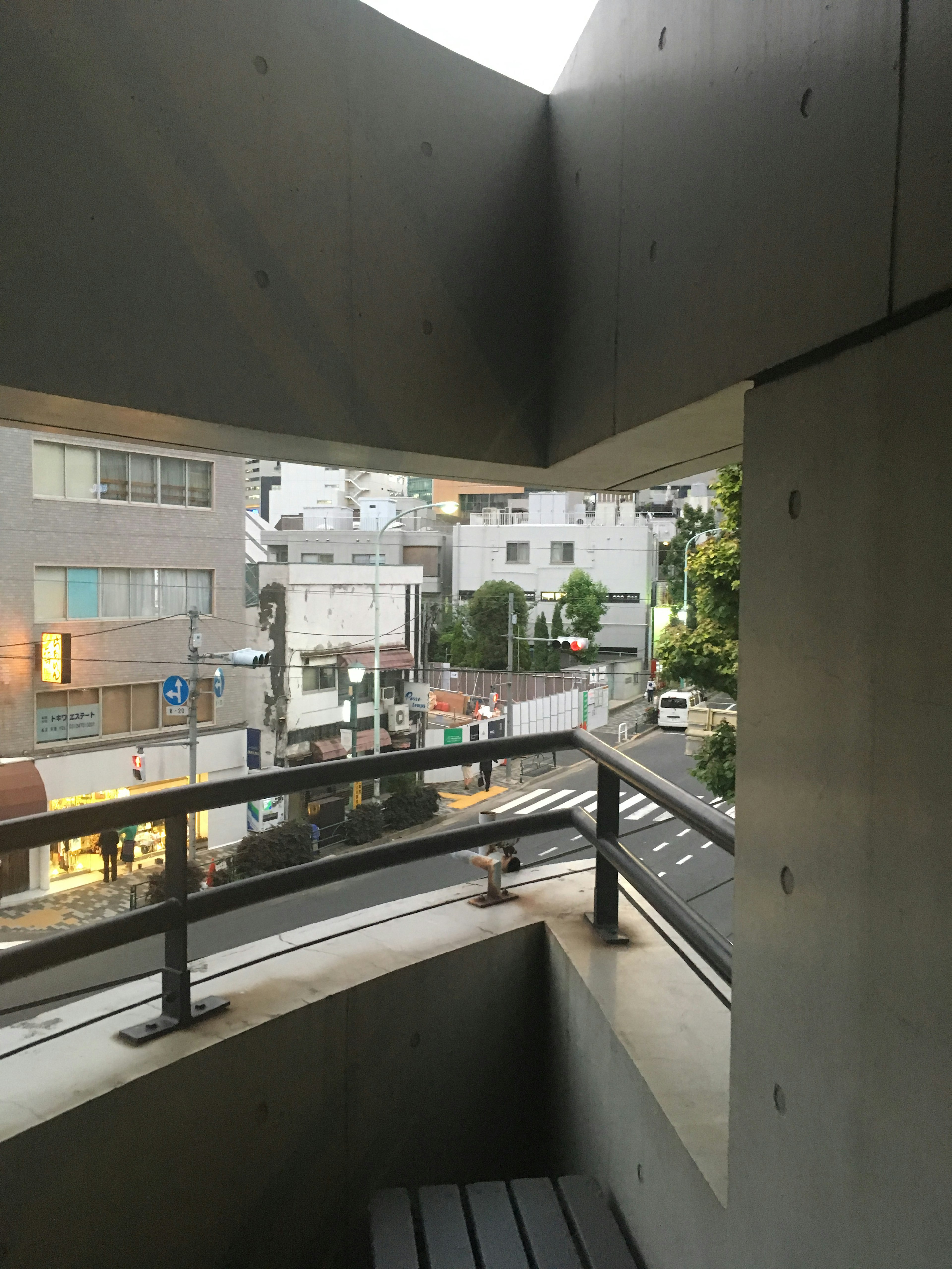 Concrete balcony view of the street surrounding buildings and traffic