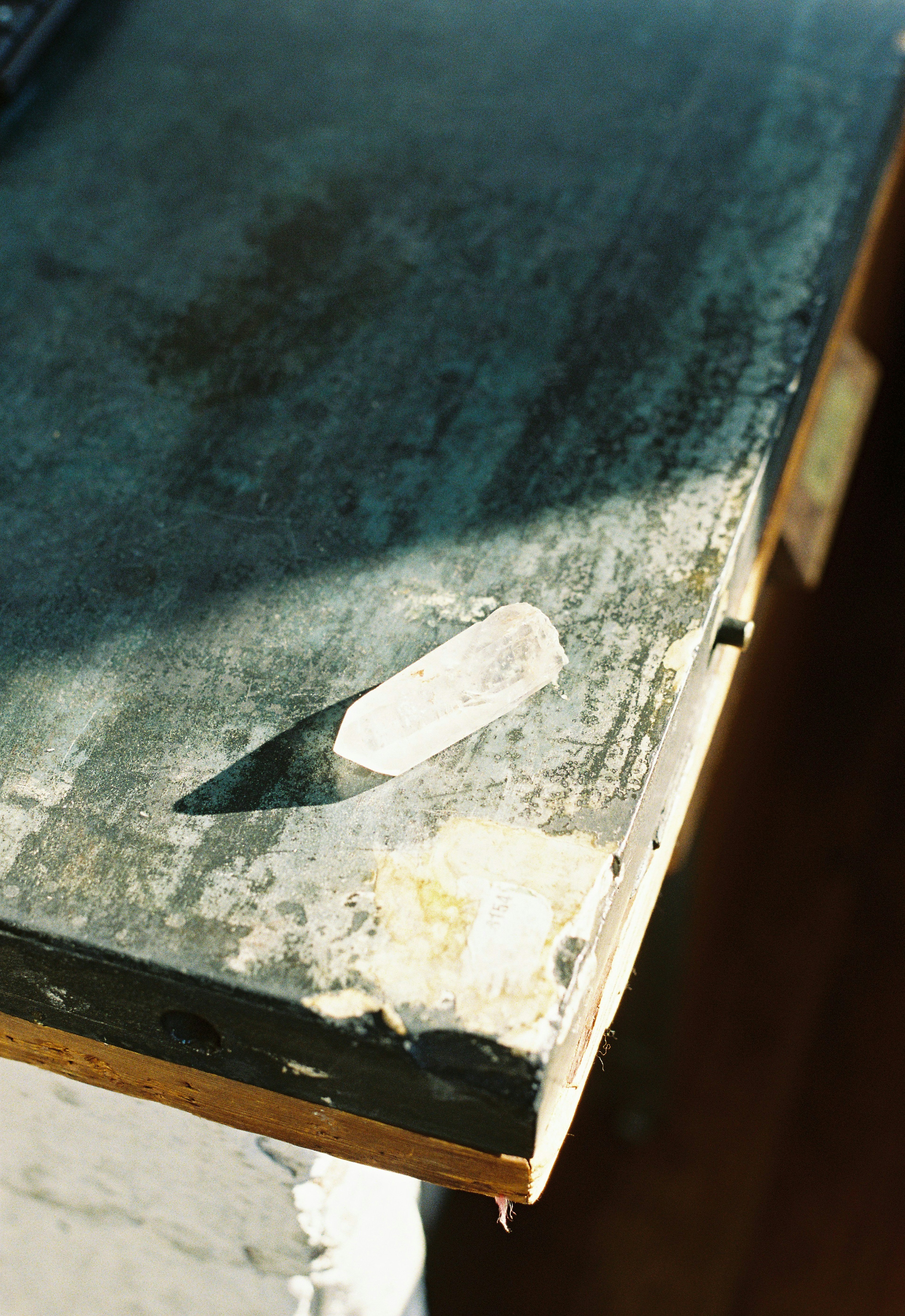 White chalk placed on a wooden table with sunlight reflection