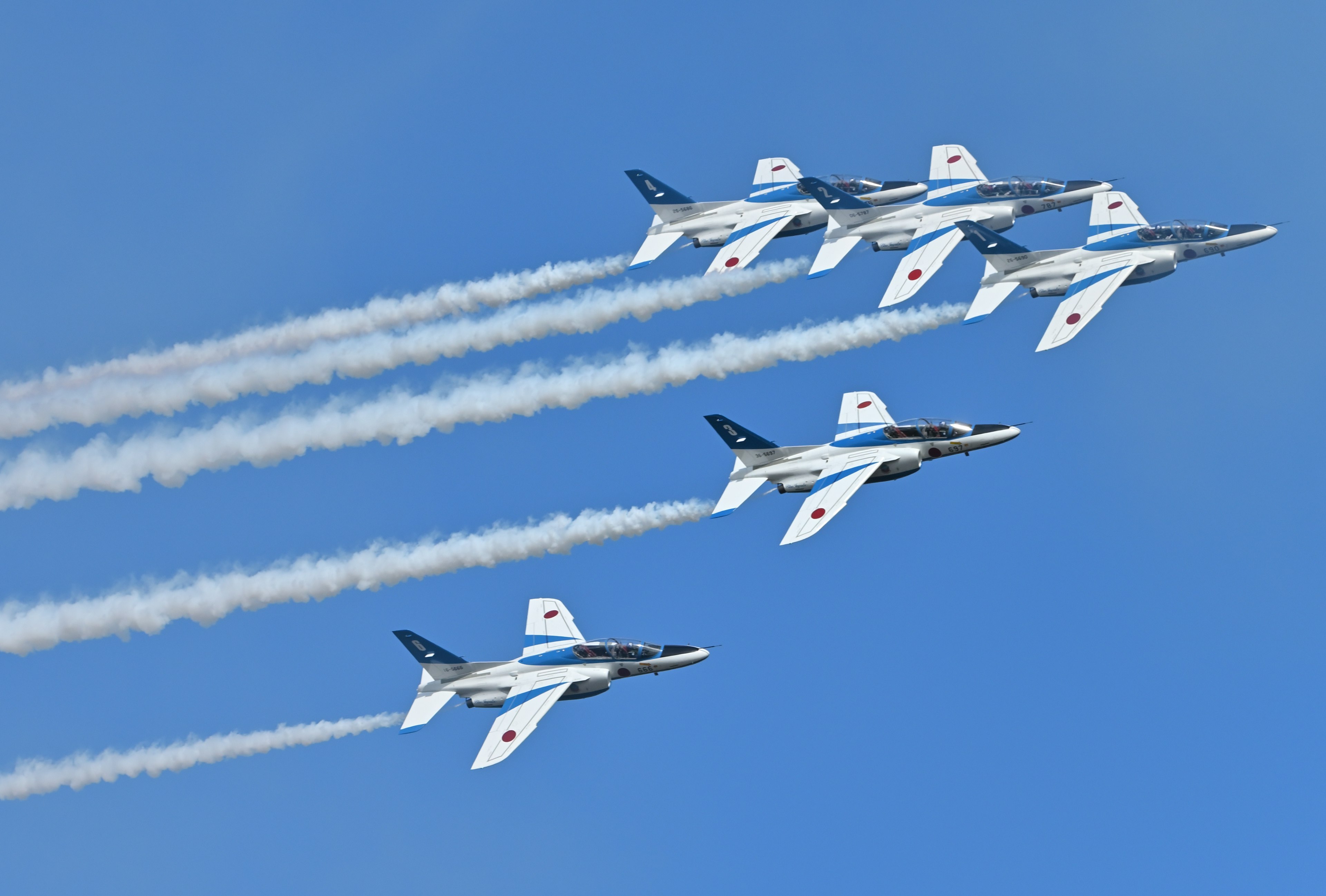 Cinque aerei da combattimento in volo in formazione contro un cielo blu