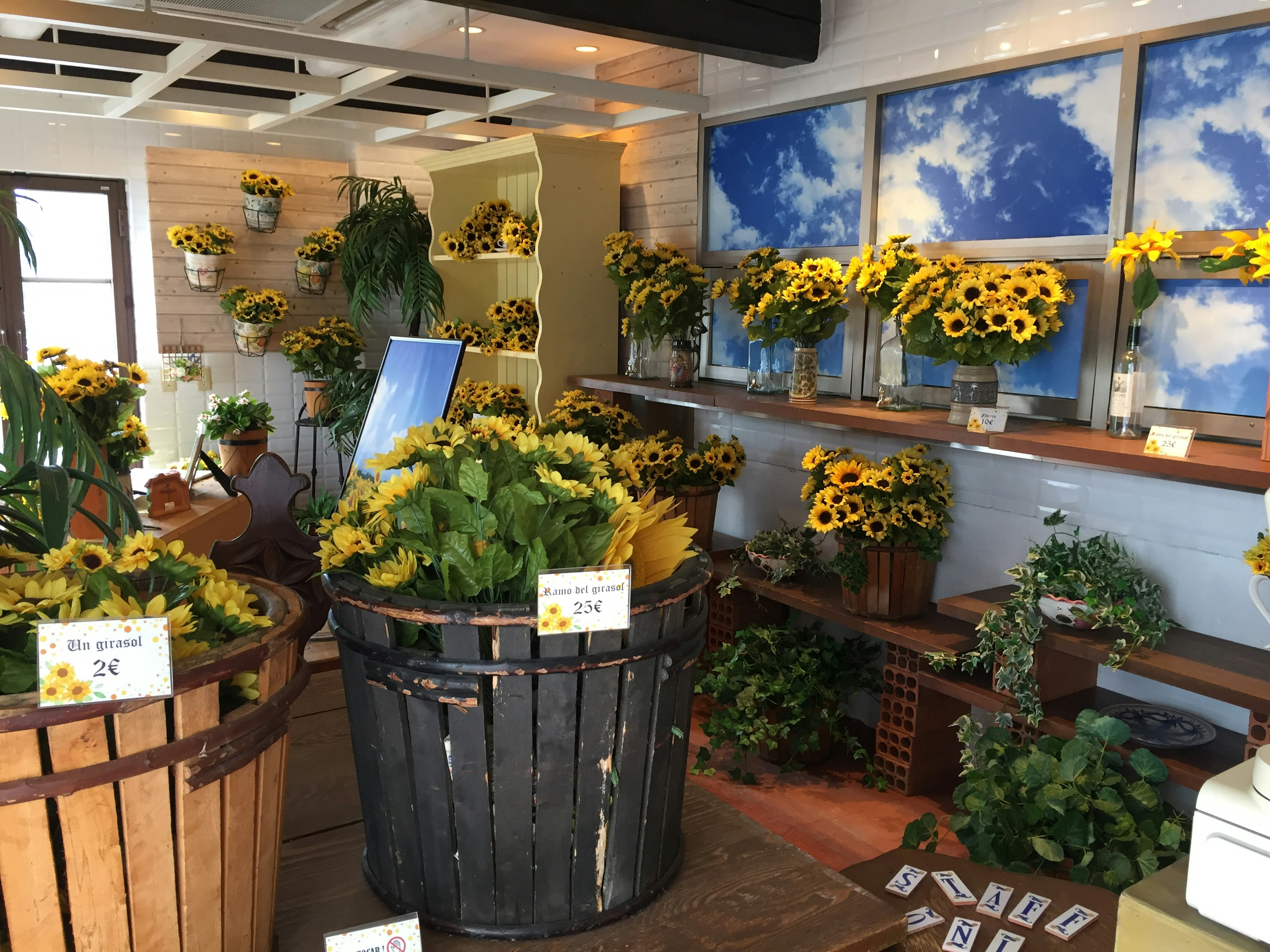 Interior of a flower shop featuring bright sunflowers and green plants