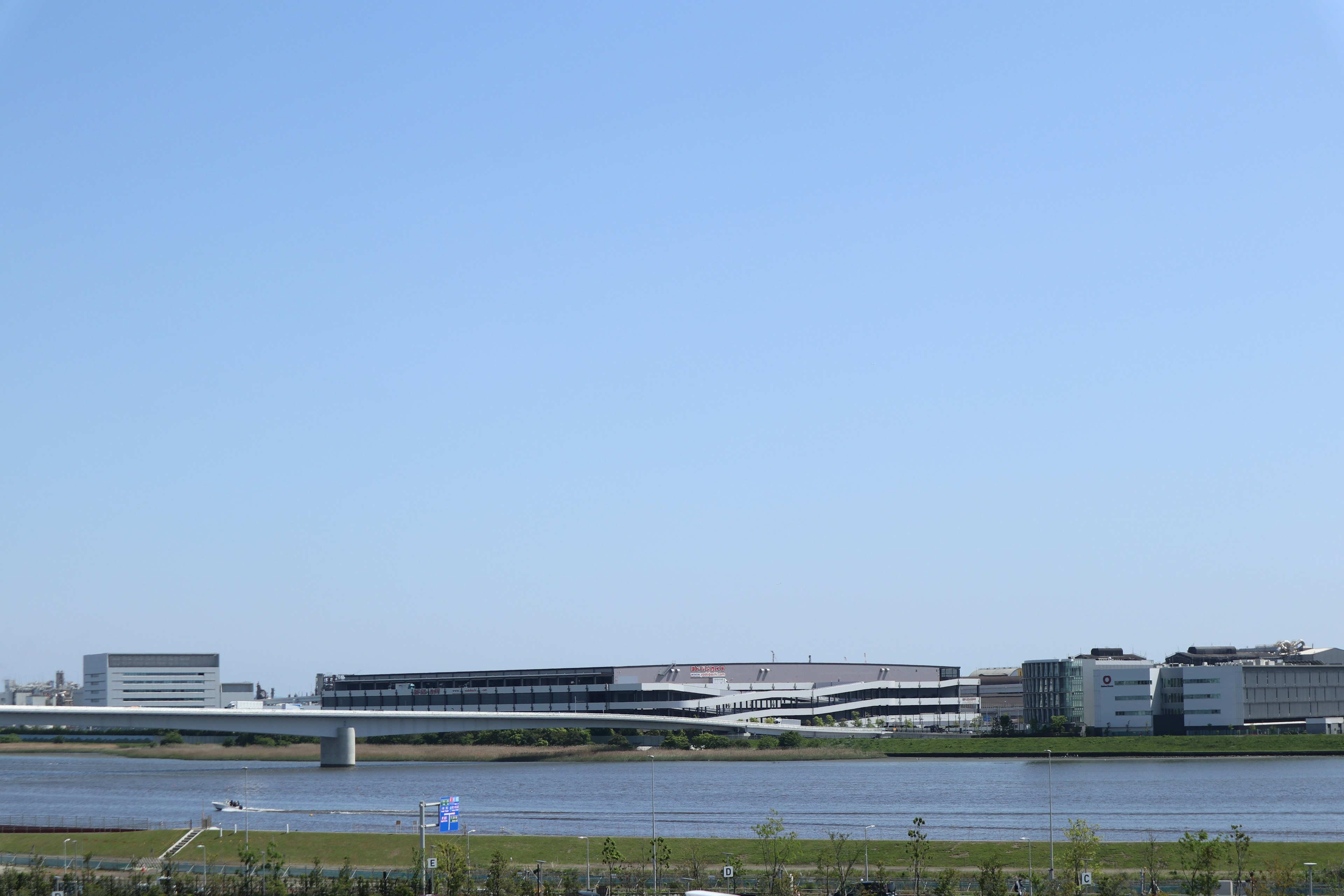 Modern buildings and river landscape under a clear blue sky