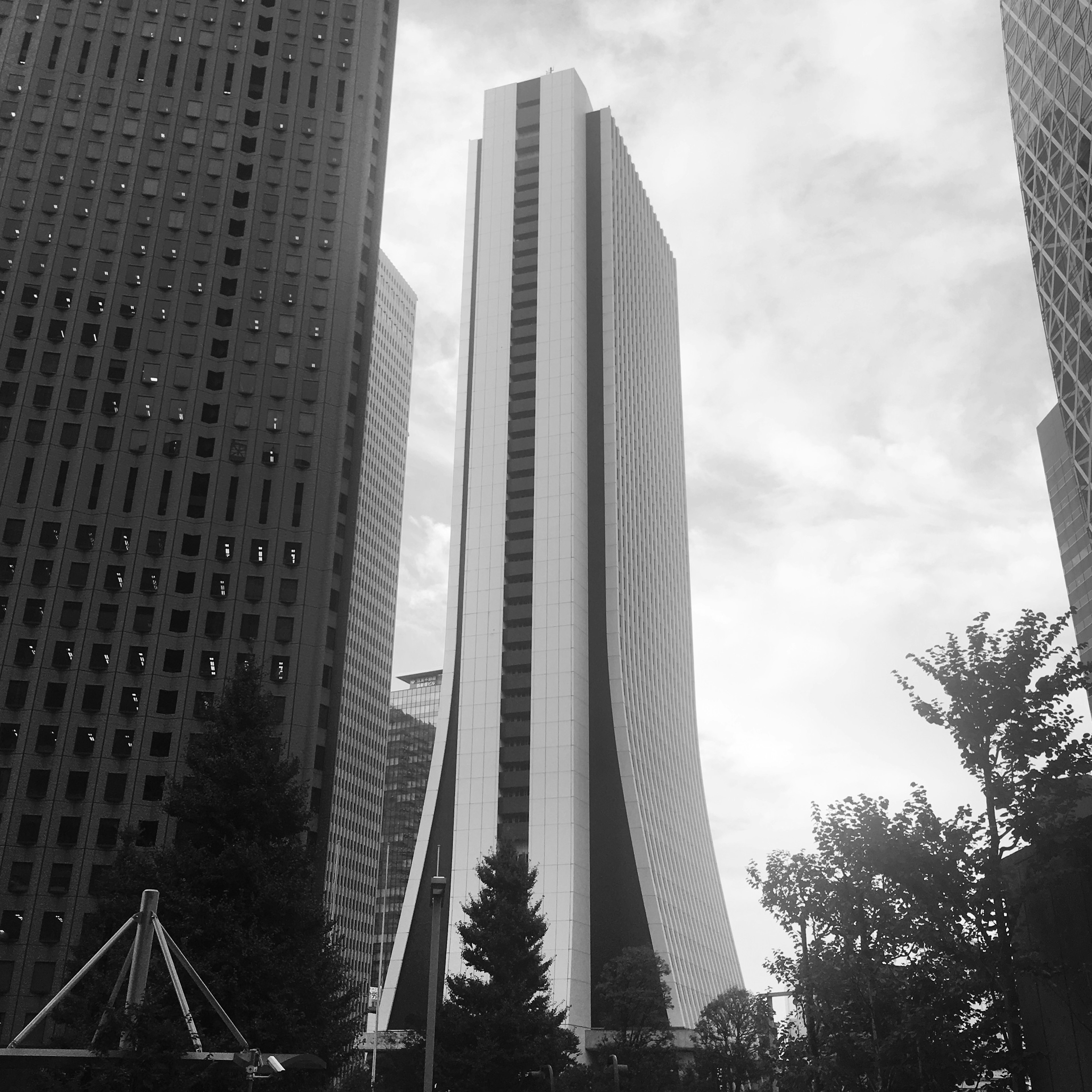 Paisaje urbano con rascacielos que presenta un edificio de diseño único en blanco y negro