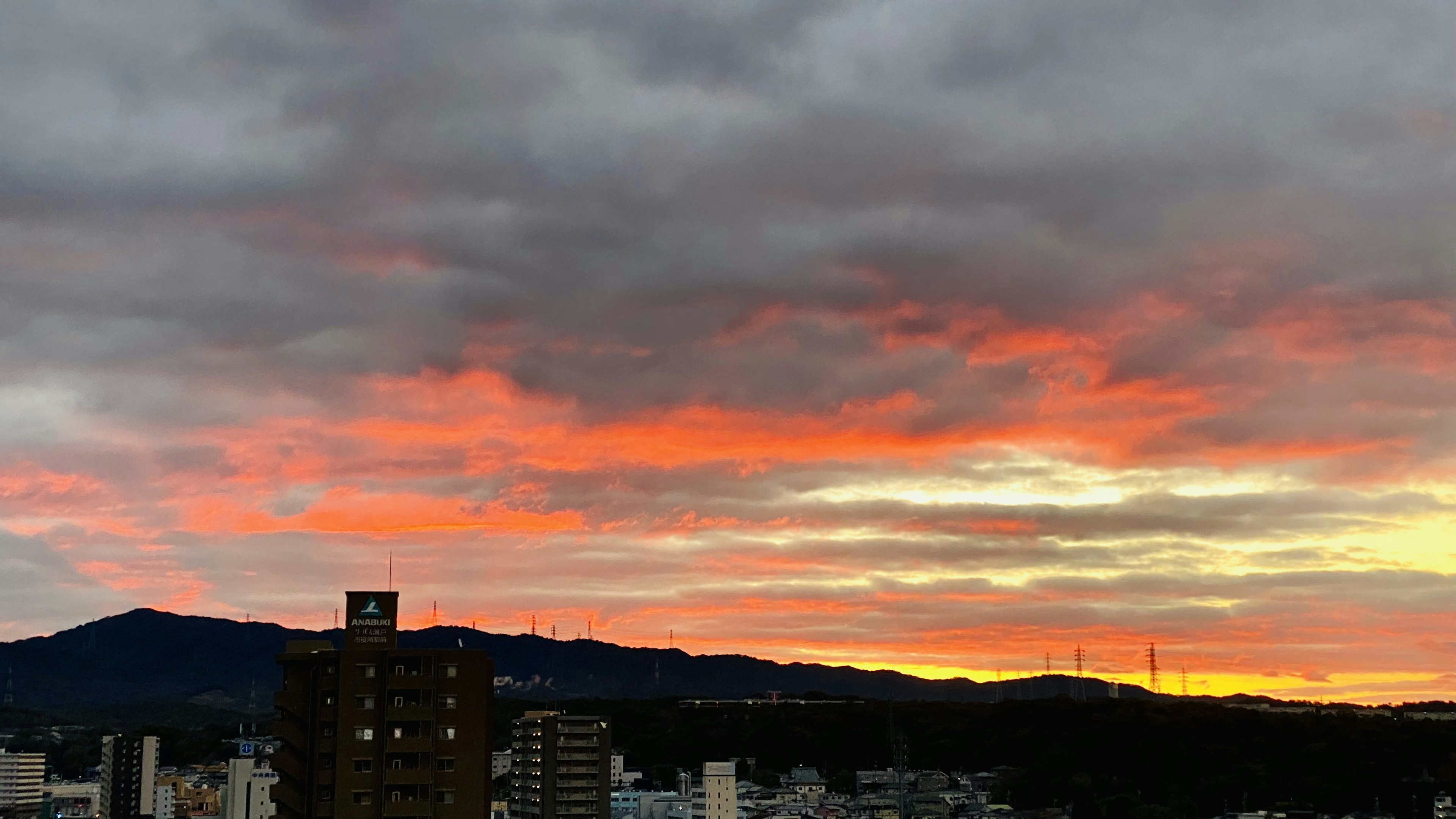 Horizonte de la ciudad al atardecer con nubes naranjas y moradas