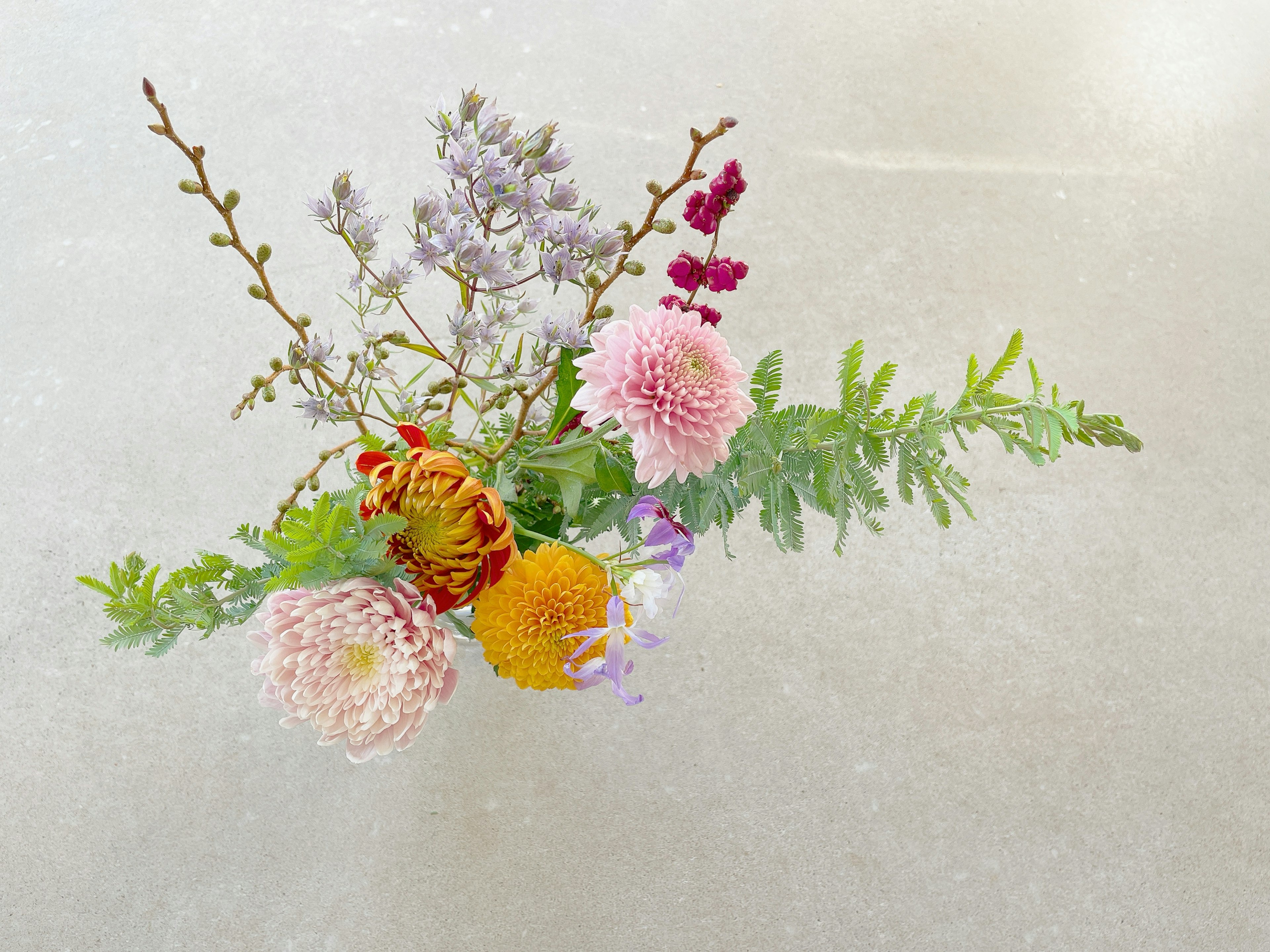 Un bouquet splendidamente disposto con fiori colorati e foglie verdi