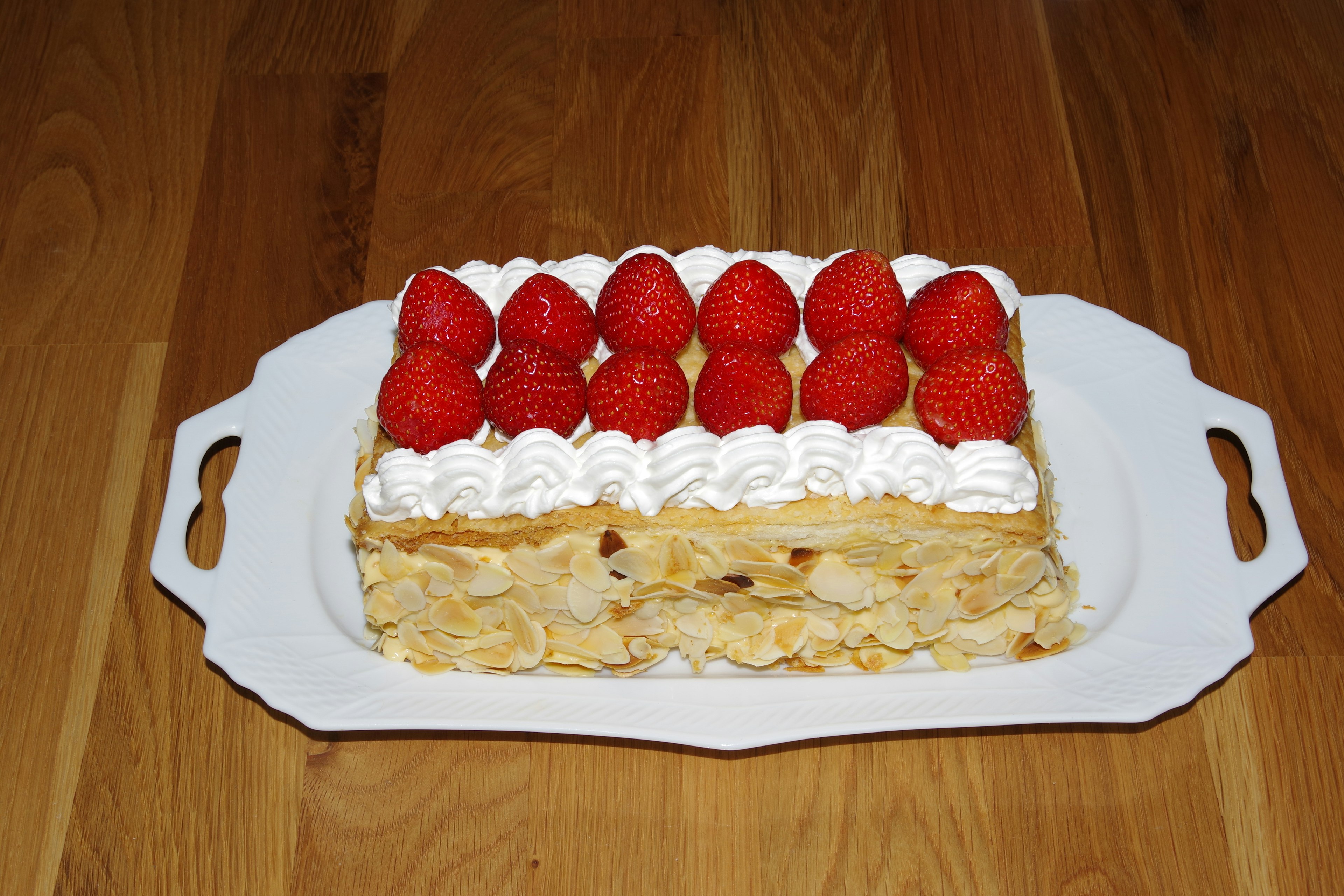 Dessert cake topped with cream and strawberries