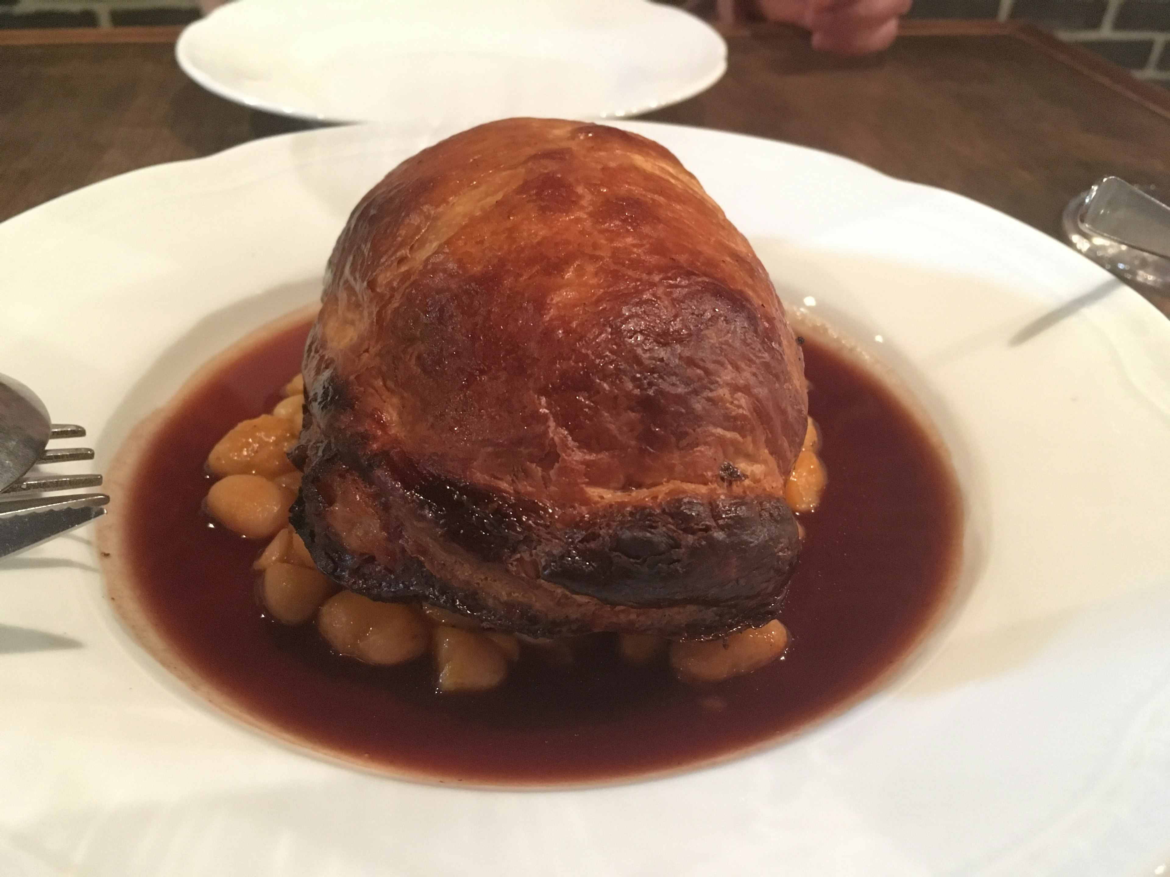 Un plato de carne bellamente presentado con salsa alrededor