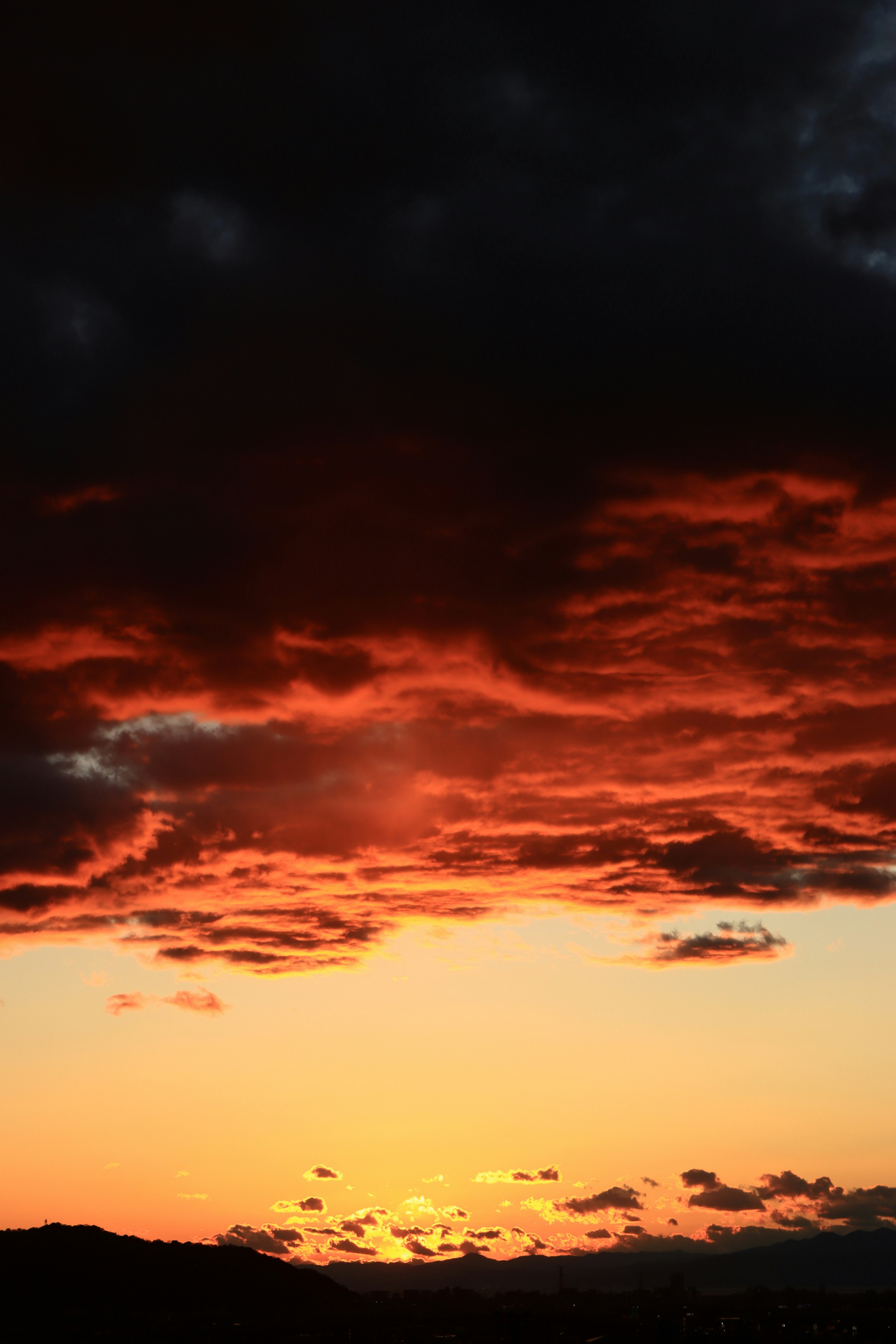 Coucher de soleil magnifique avec des nuances oranges vives et des nuages sombres