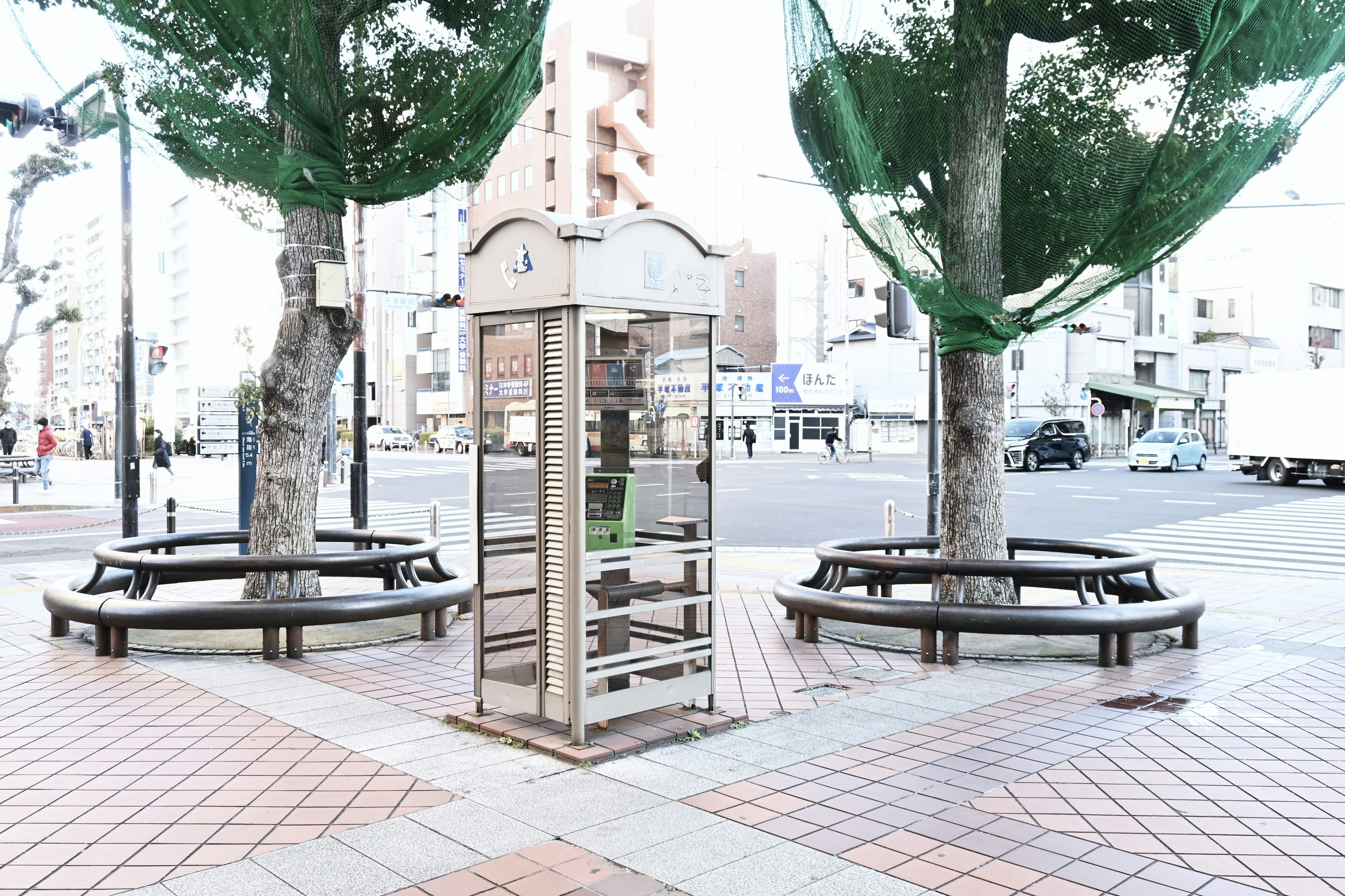 Une scène de parc avec une cabine téléphonique entourée de bancs et d'arbres