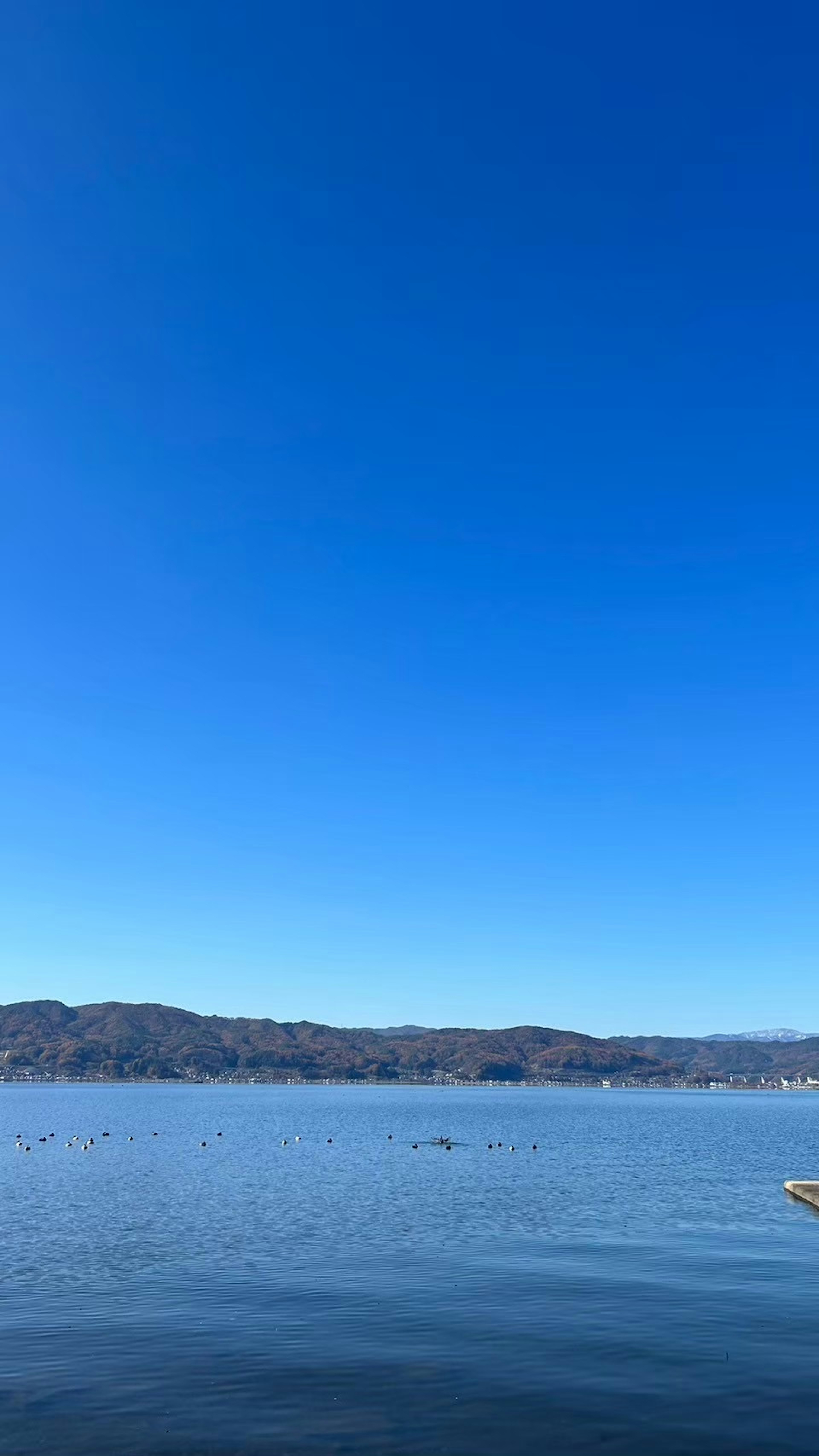 青空と静かな湖の風景山々が背景に広がる