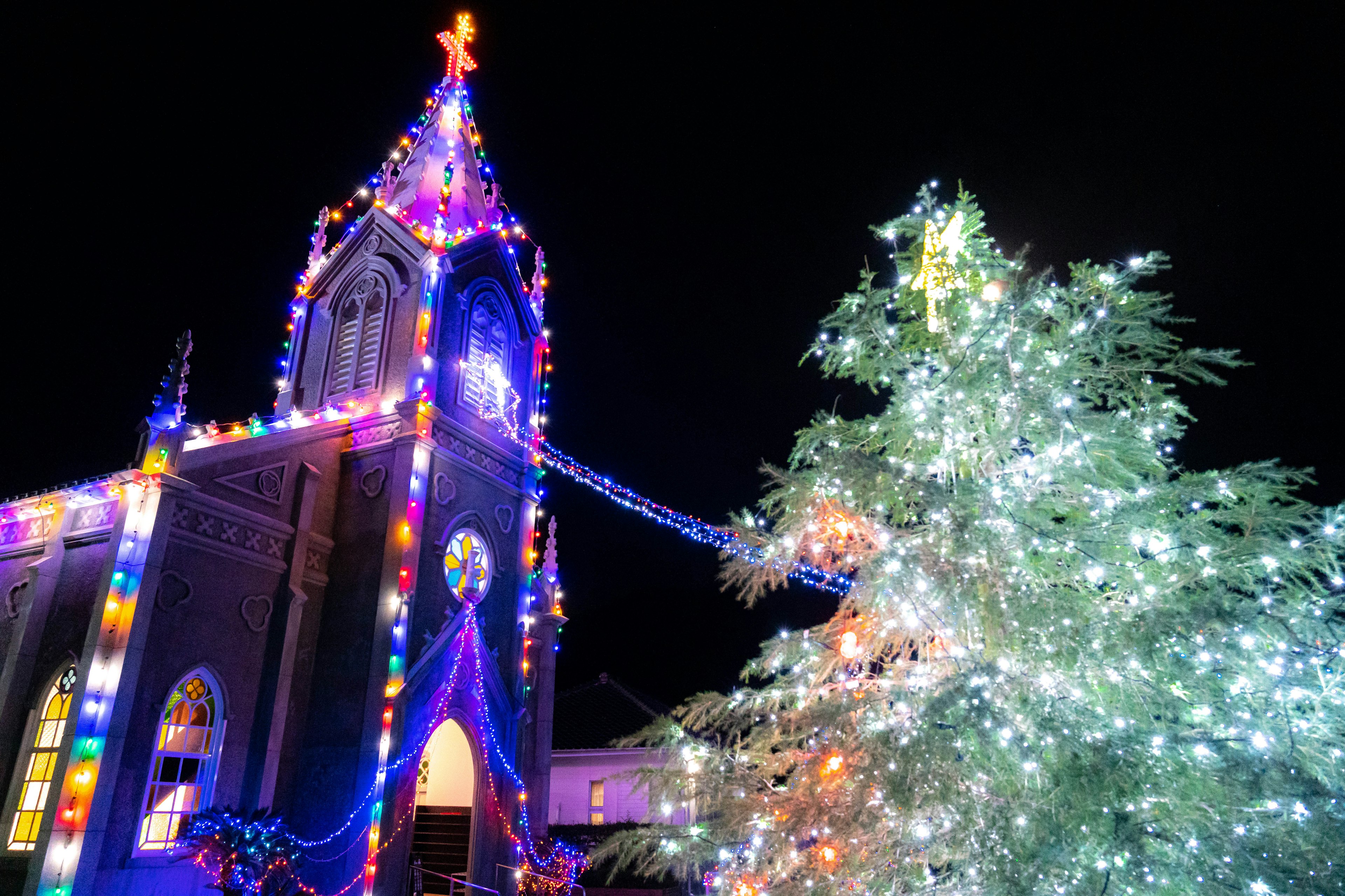 Chiesa addobbata con luci di Natale e albero di Natale luminoso di notte