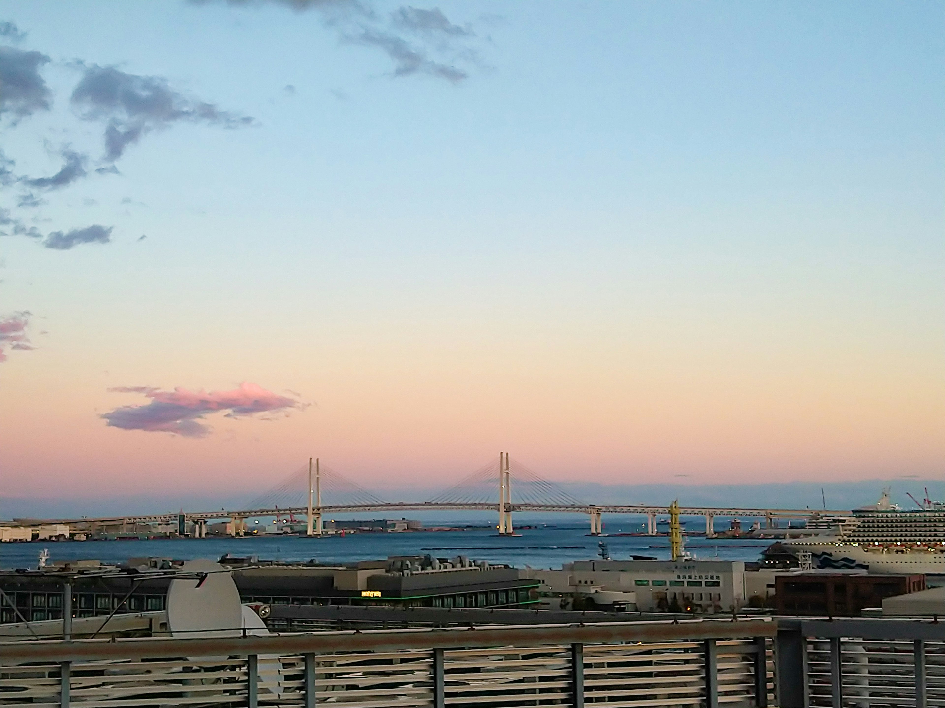 Ciel de coucher de soleil sur la mer avec un pont et des bâtiments