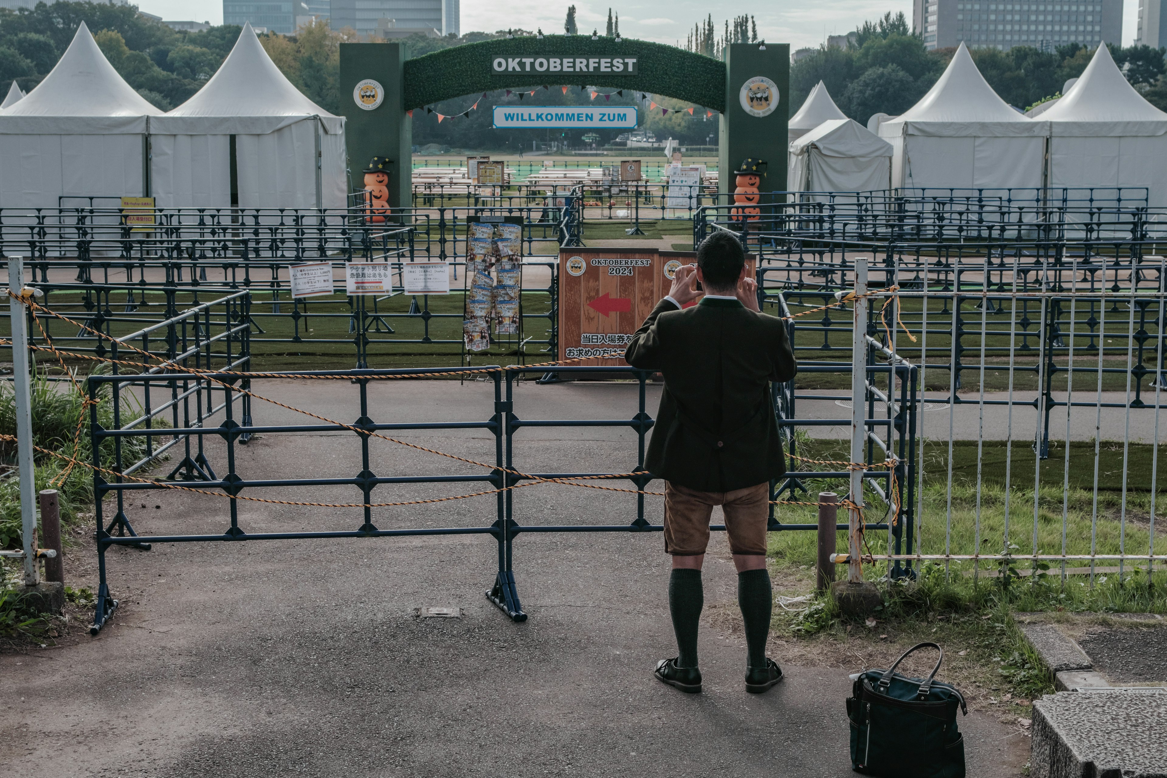 Un uomo che guarda il cancello d'ingresso con tende sullo sfondo in un evento