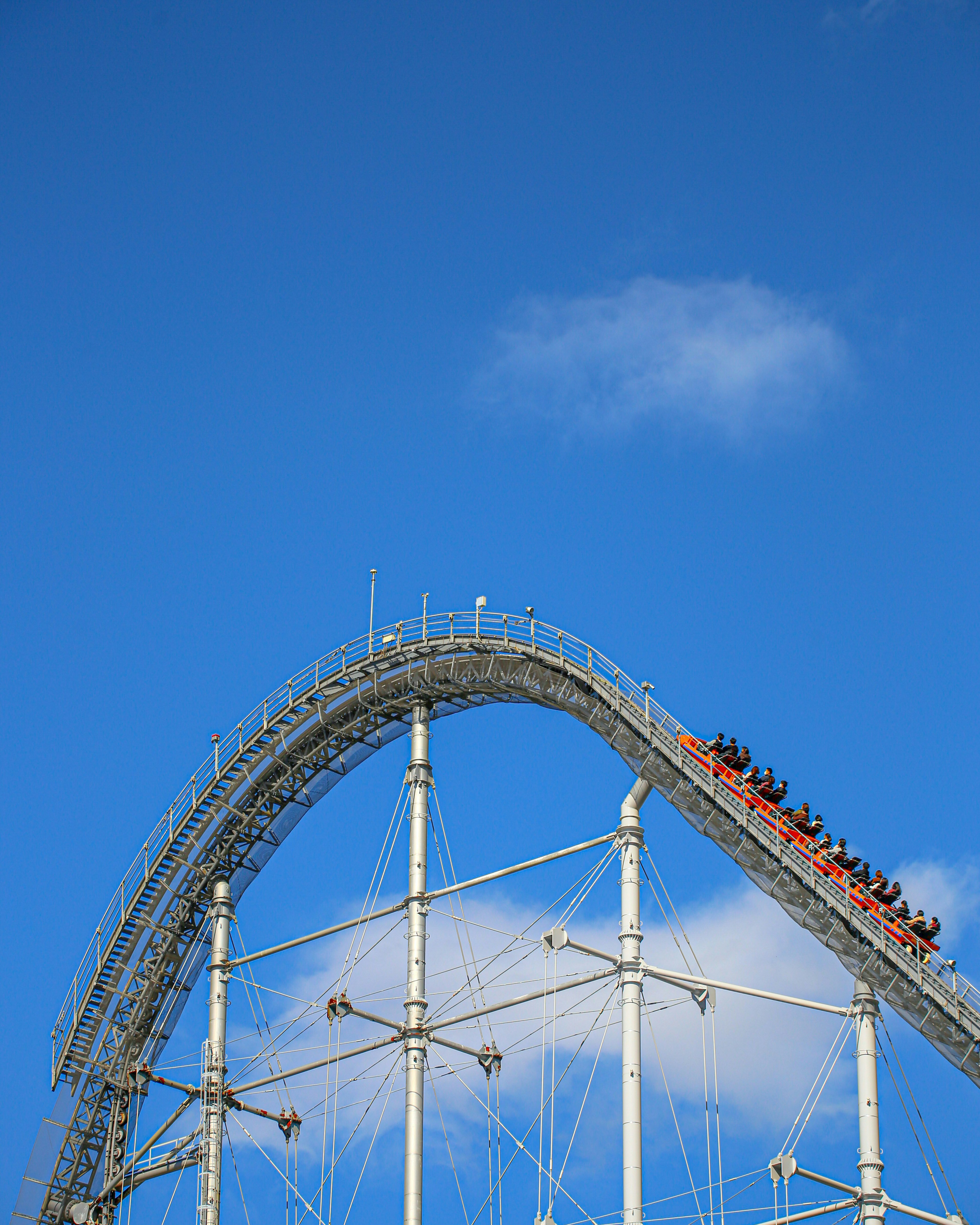 Hohe Kurve einer Achterbahn unter einem blauen Himmel