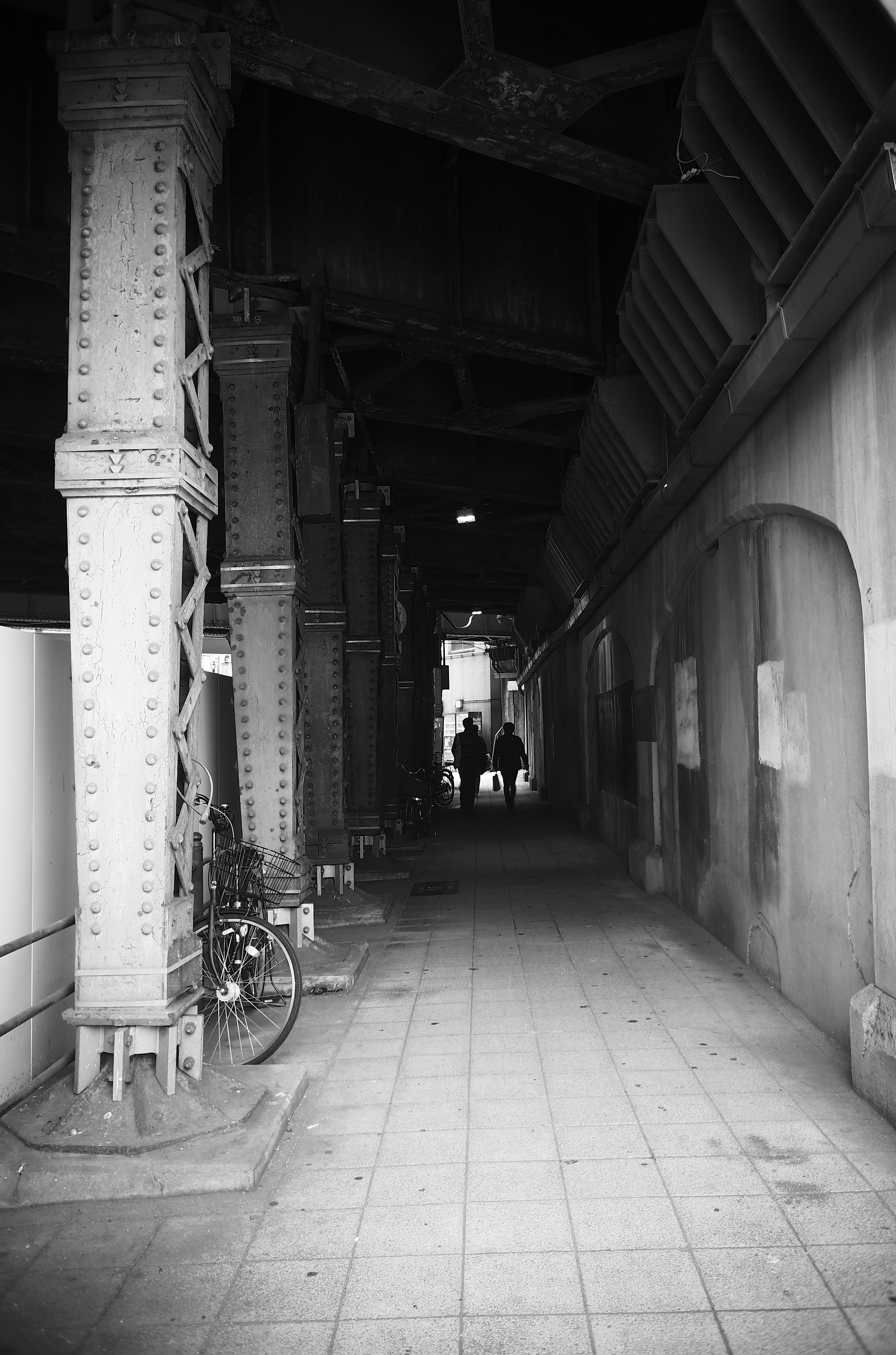 Couloir sombre avec une silhouette de personne et un vélo