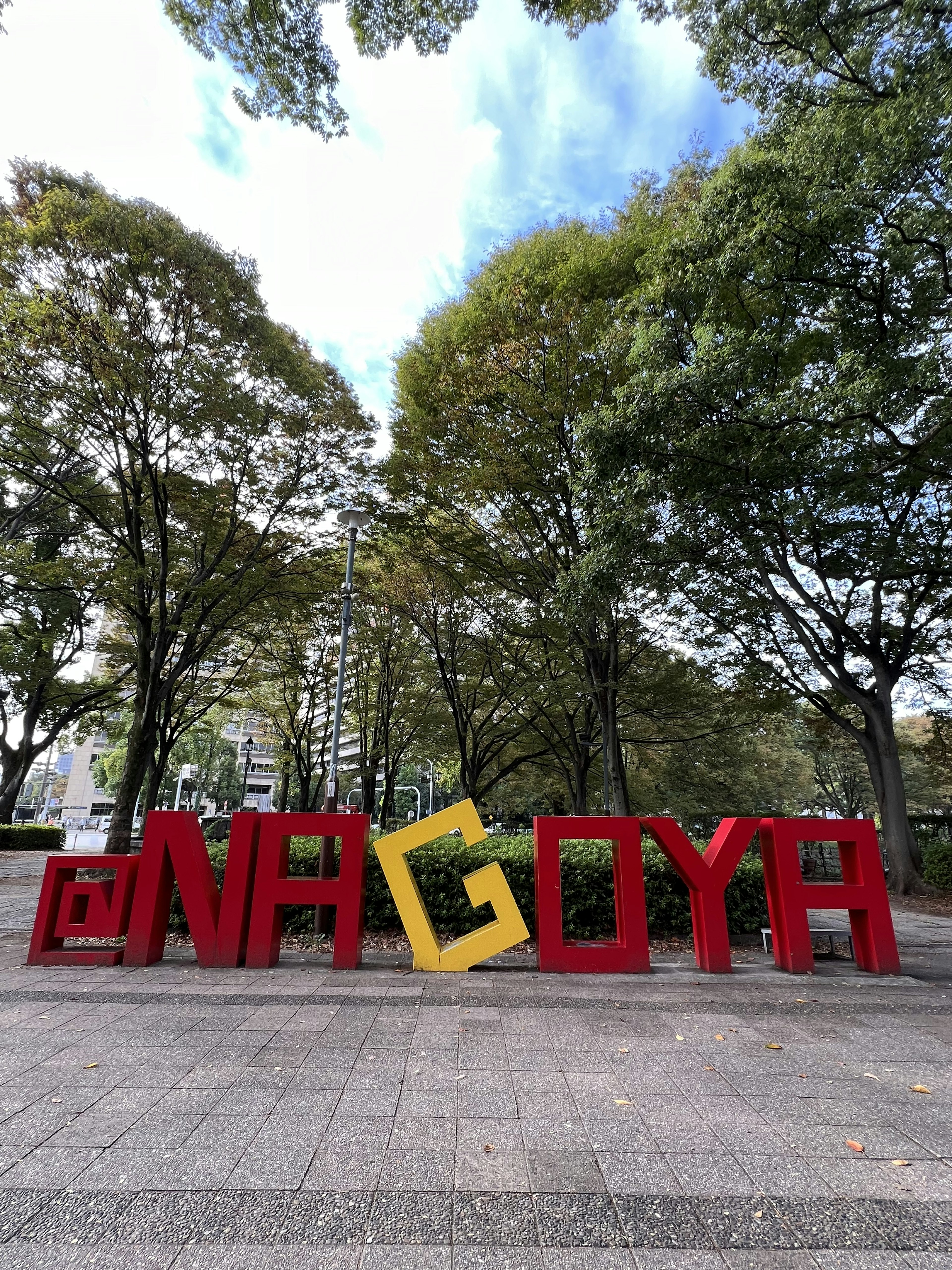 Tanda besar Nagoya di taman dikelilingi pepohonan